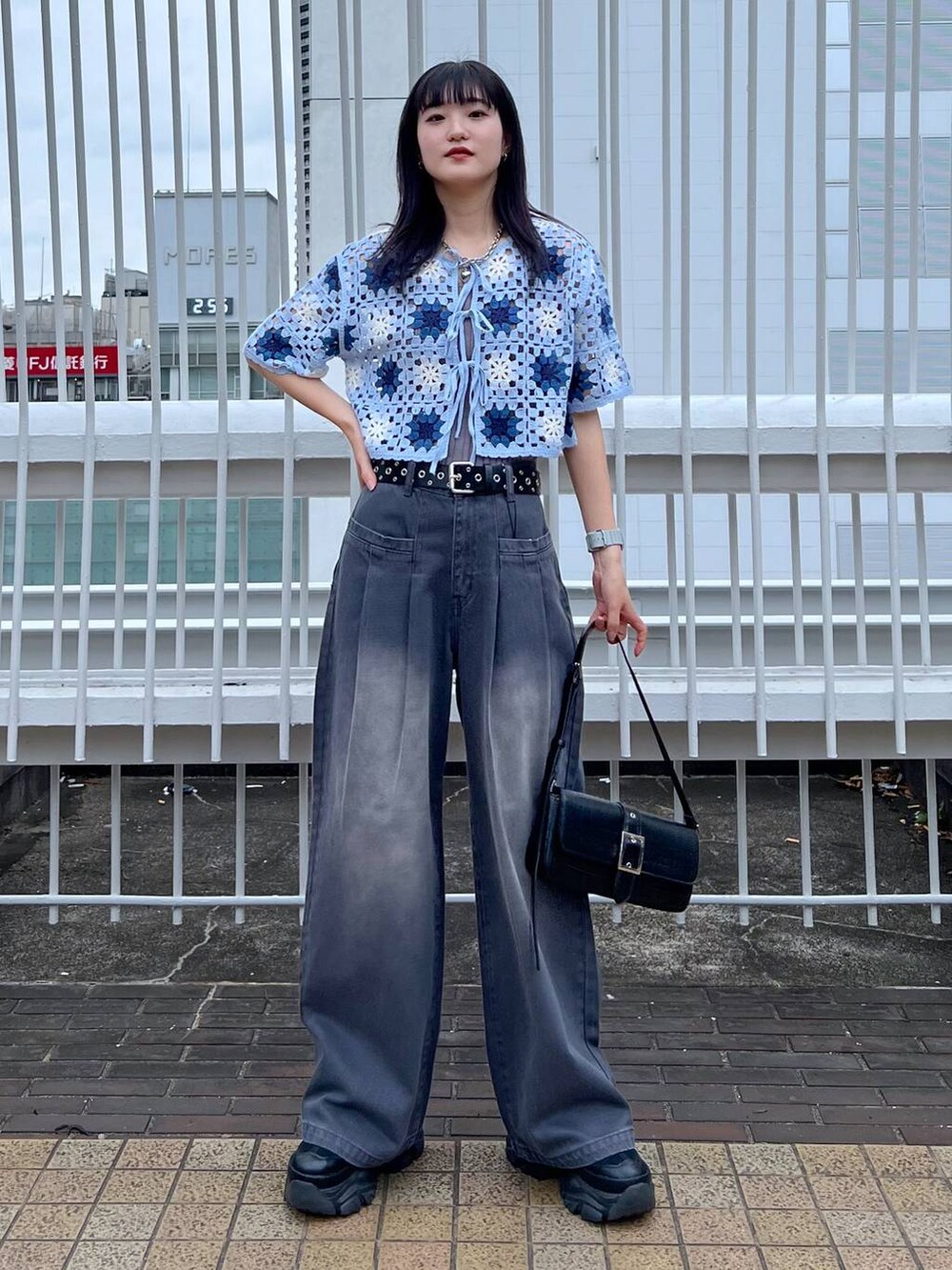 グレー系のタンクトップ、ブラック系のスニーカー、ブラック系のハンドバッグを着用したレディースの夏コーディネートの3枚目の写真