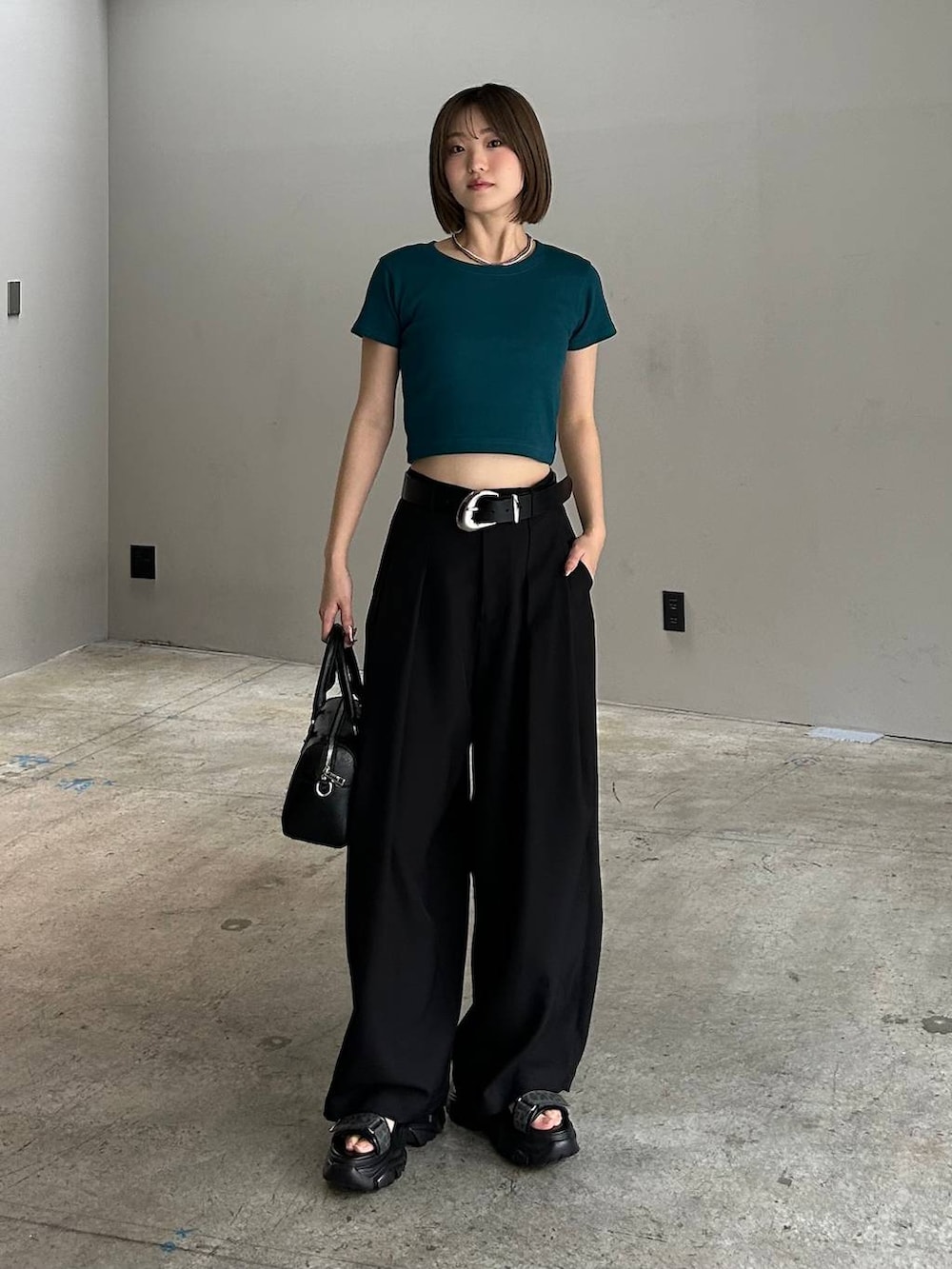 ブラック系のボストンバッグ、ブラック系のサンダル、ブラック系のスラックスを着用したレディースの春コーディネートの7枚目の写真