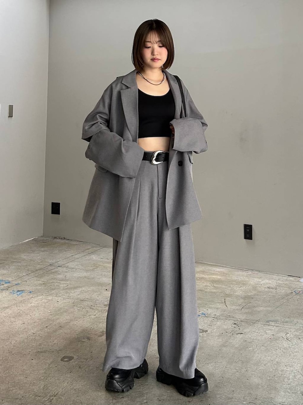 ブラック系のブーツ、ブラック系のキャミソール、ブラック系のハンドバッグを着用したレディースの春コーディネートの4枚目の写真