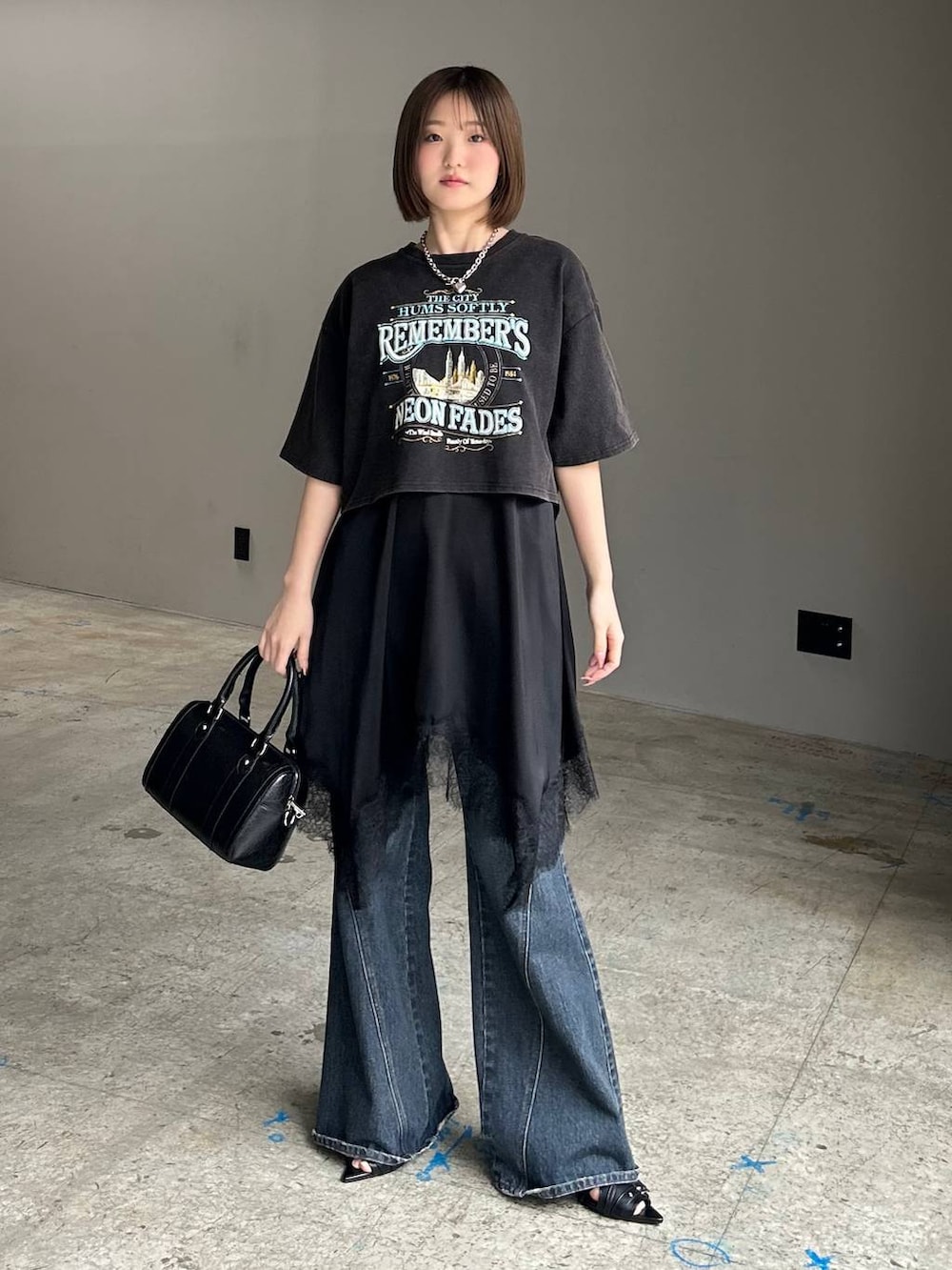 ブルー系のデニムパンツ、ブラック系のボストンバッグ、ブラック系のサンダルを着用したレディースの春コーディネートの3枚目の写真