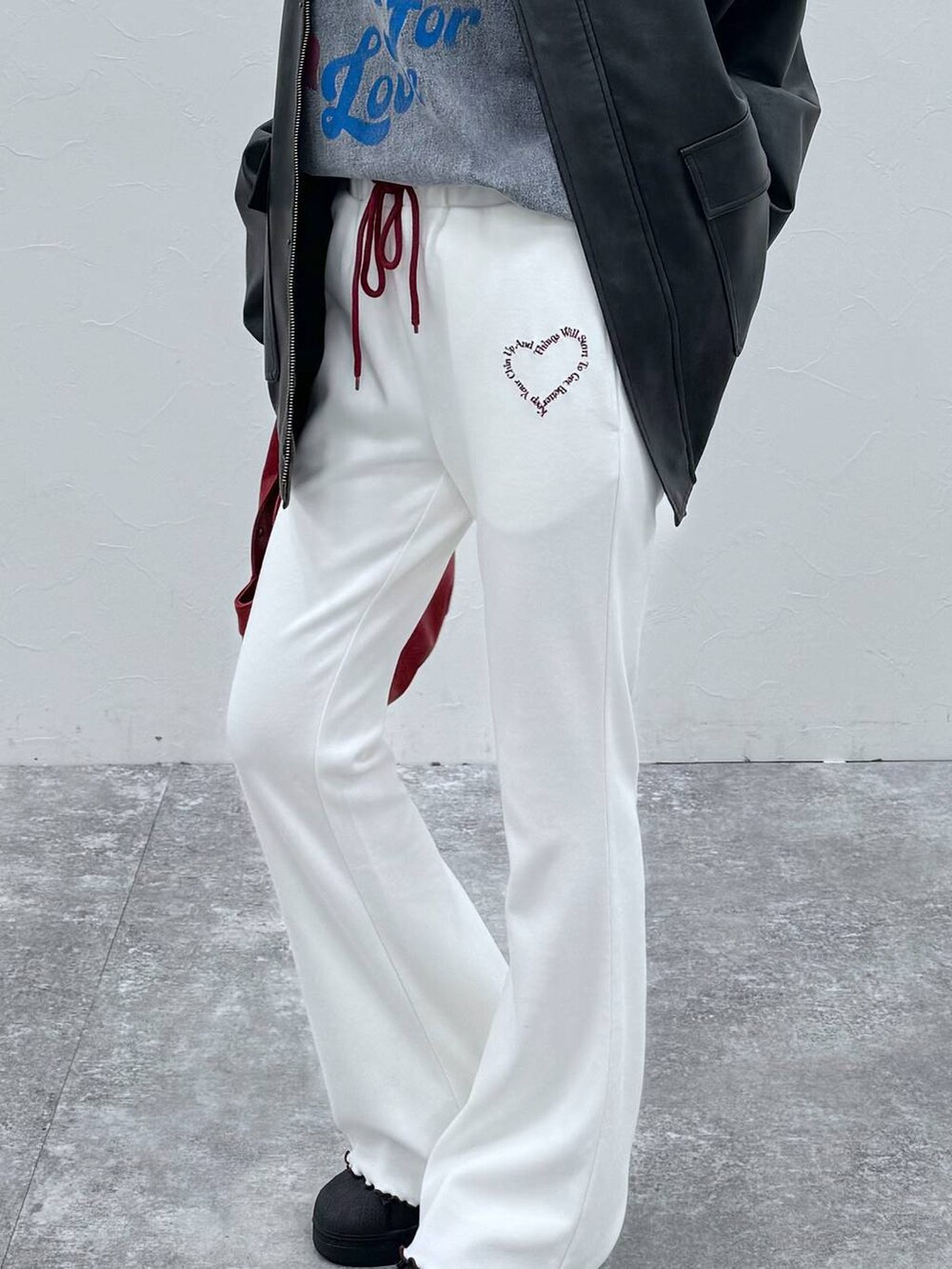 ブラック系のブルゾン、レッド系のハンドバッグ、ベージュ系のその他パンツを着用したレディースの冬コーディネートの4枚目の写真