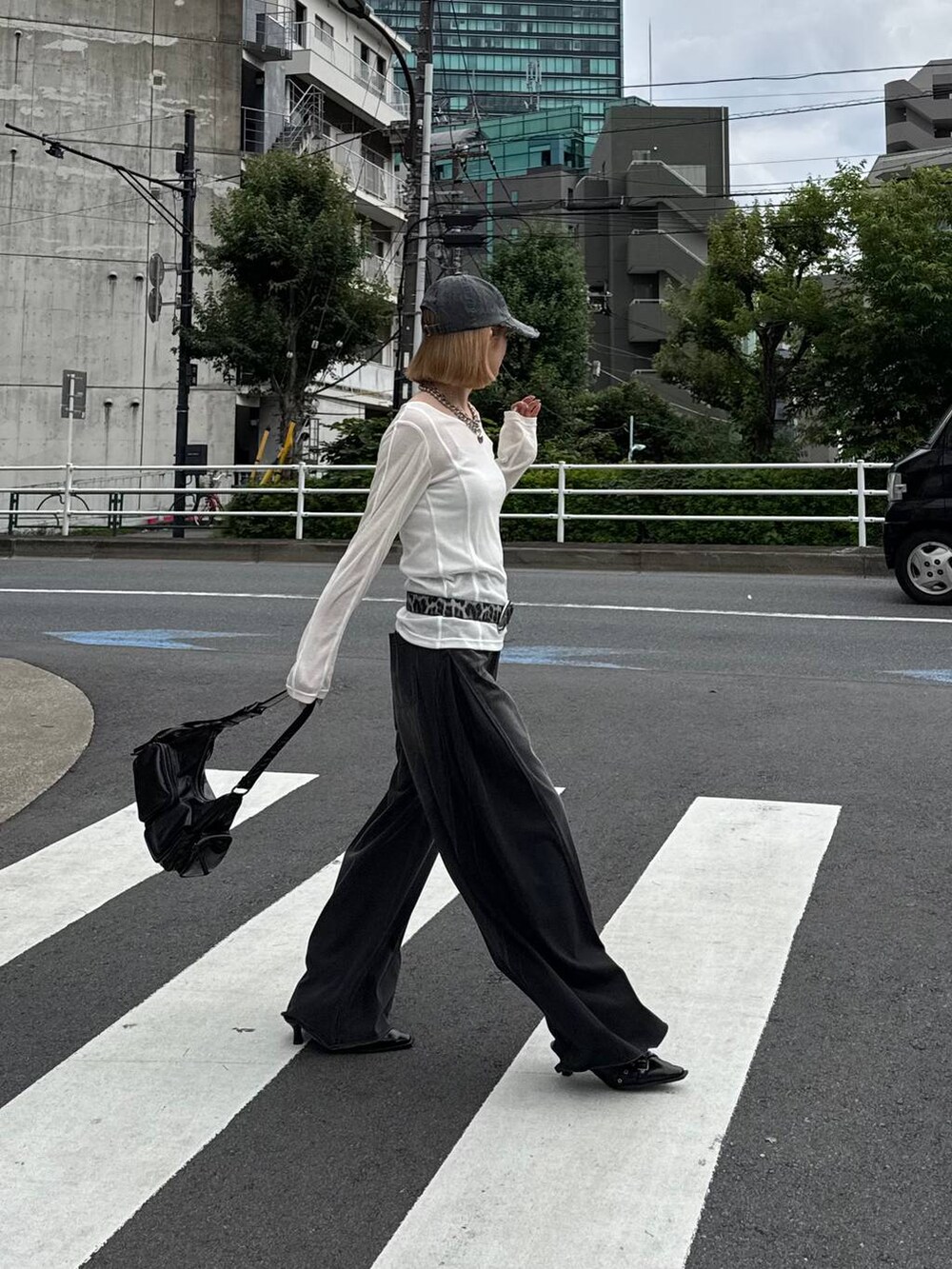 ブラック系のデニムパンツ、ブラック系のショルダーバッグ、ブラック系のキャップを着用したレディースの夏コーディネートの5枚目の写真