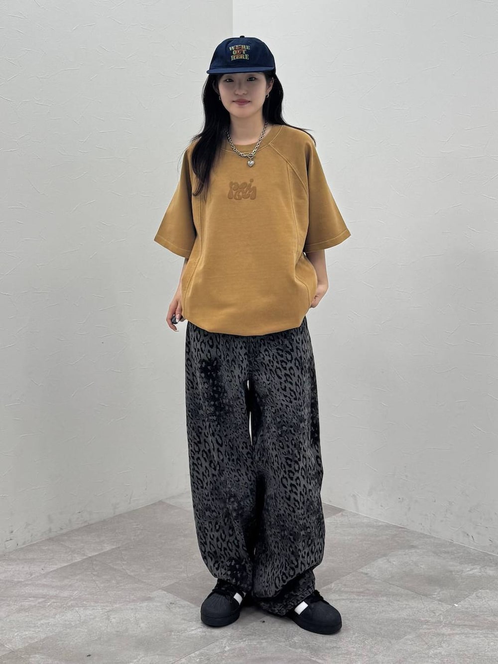 ブラック系のデニムパンツ、イエロー系のTシャツ/カットソー、ブルー系のキャップを着用したレディースの春コーディネートの5枚目の写真