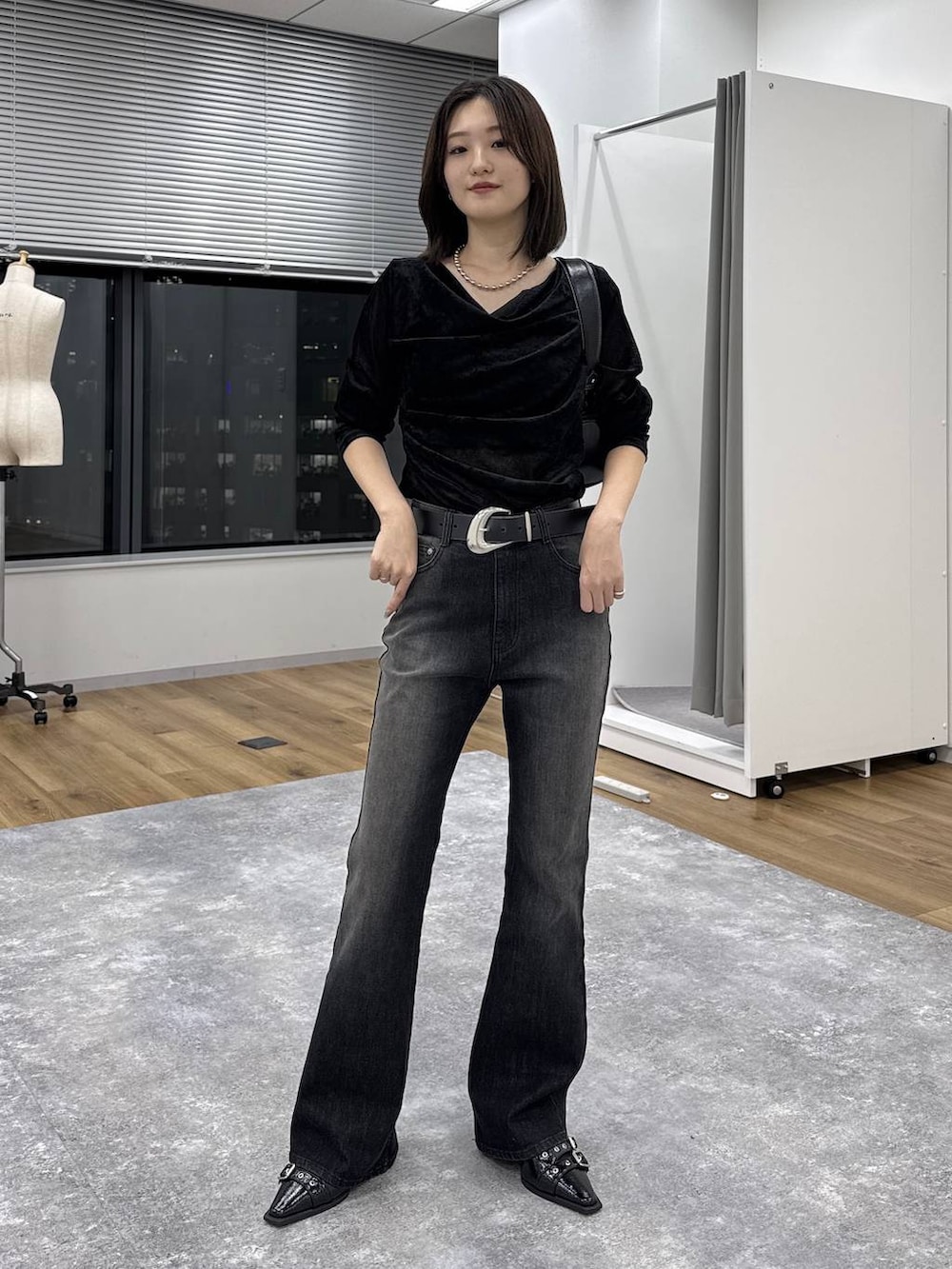 ブラック系のTシャツ/カットソー、ブルー系のデニムパンツ、ブラック系のショルダーバッグを着用したレディースの秋コーディネートの2枚目の写真