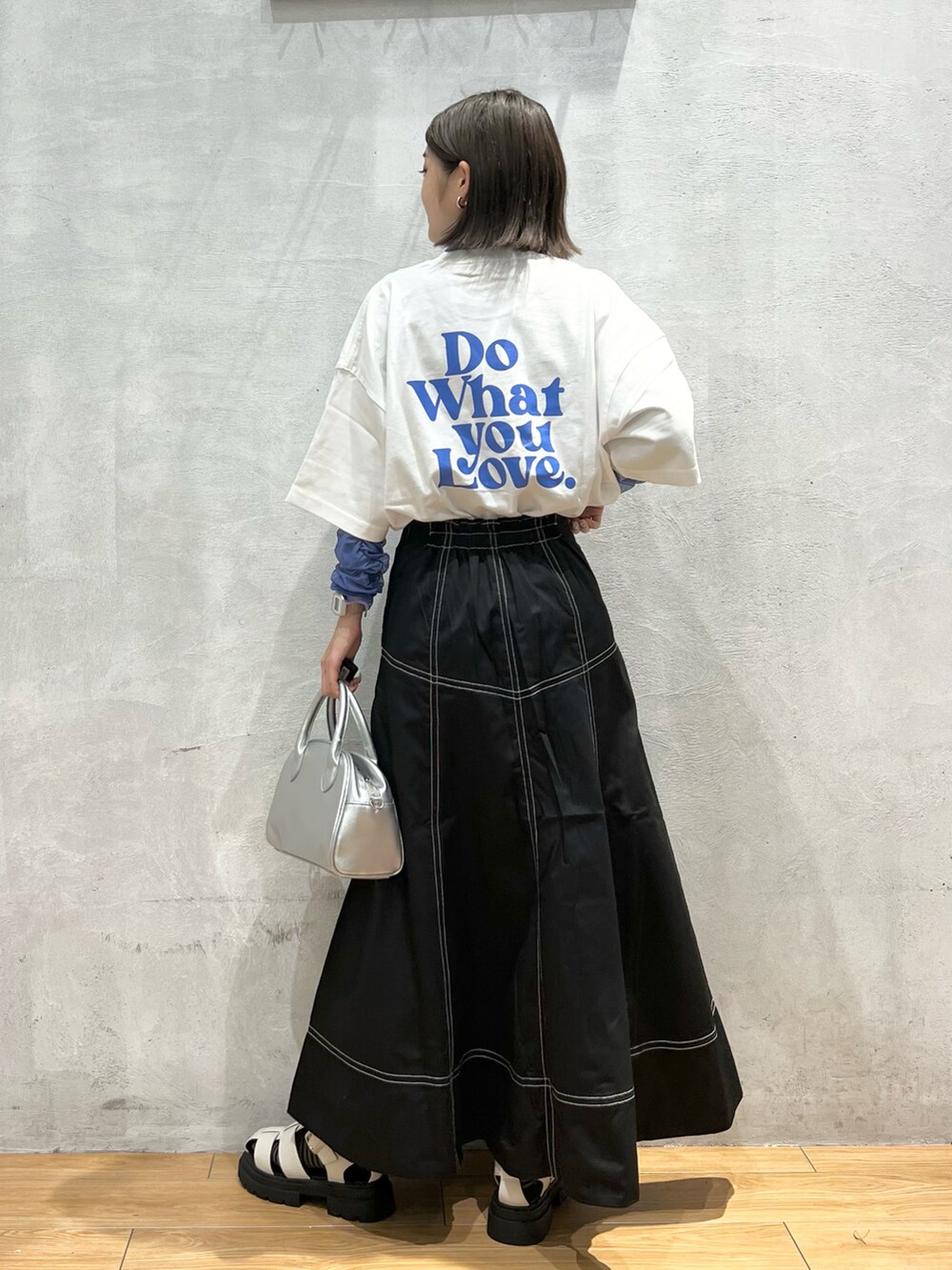 ホワイト系のサンダル、シルバー系のショルダーバッグ、ブラック系のスカートを着用したレディースの夏コーディネートの3枚目の写真