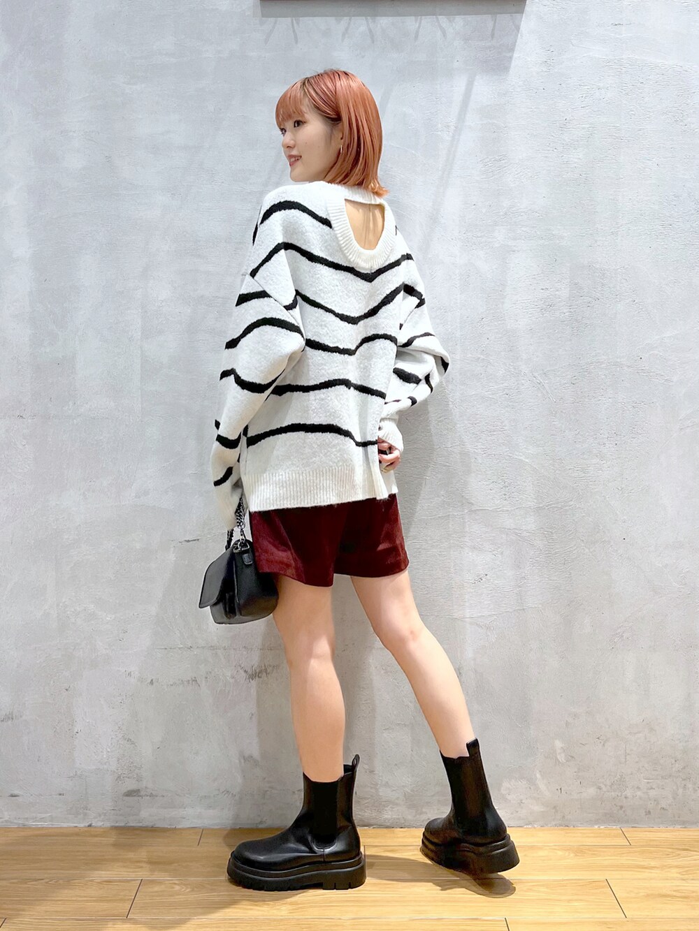 ホワイト系のニット/セーター、レッド系のその他パンツ、ブラック系のブーツを着用したレディースの秋コーディネートの2枚目の写真