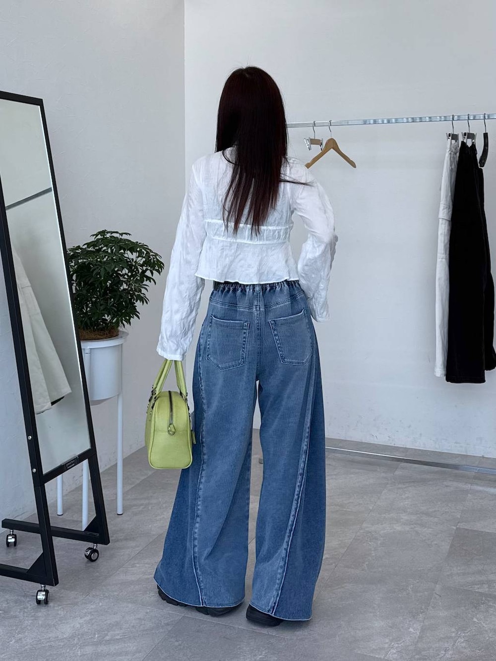 ブラック系のスニーカー、ブルー系のデニムパンツ、ホワイト系のシャツ/ブラウスを着用したレディースの春コーディネートの5枚目の写真