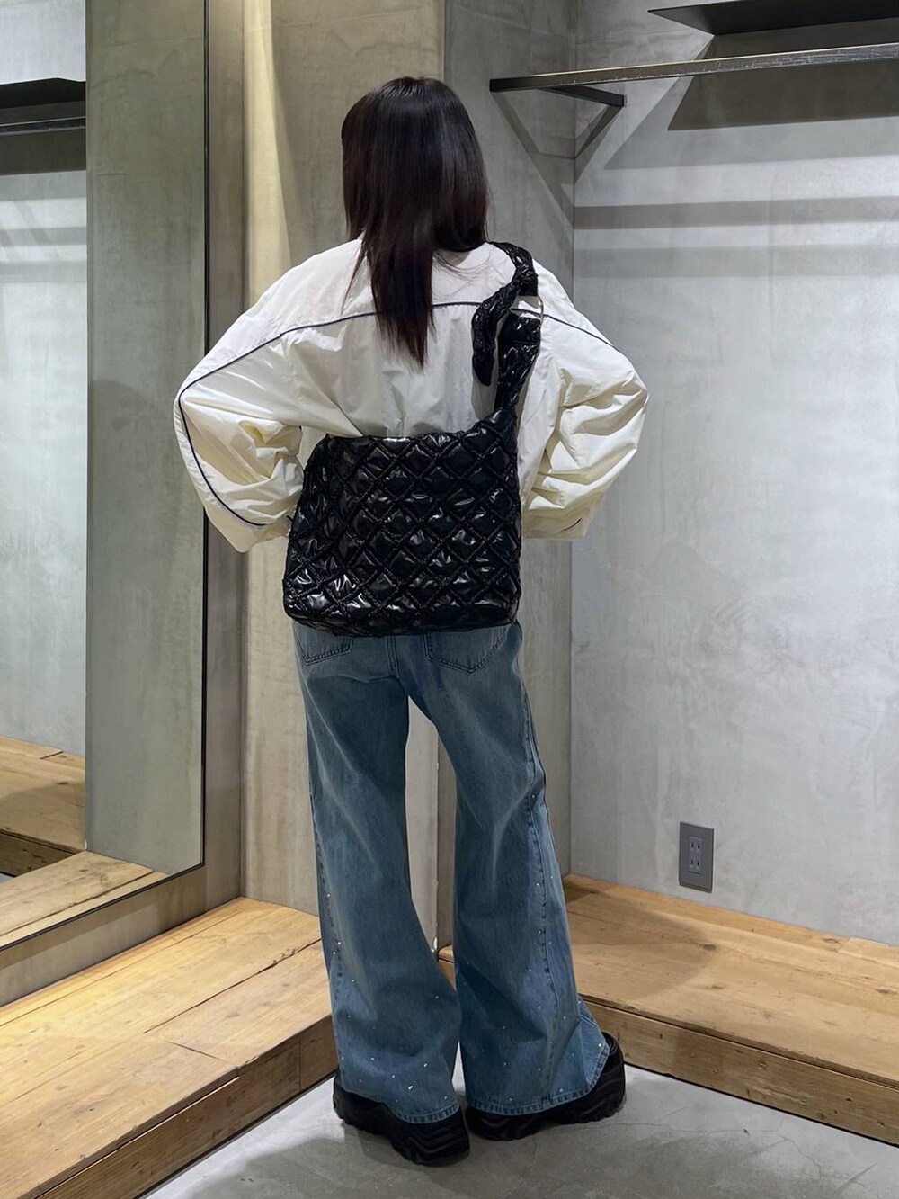 ホワイト系のブルゾン、ブルー系のキャミソール、ブルー系のデニムパンツを着用したレディースの冬コーディネートの4枚目の写真