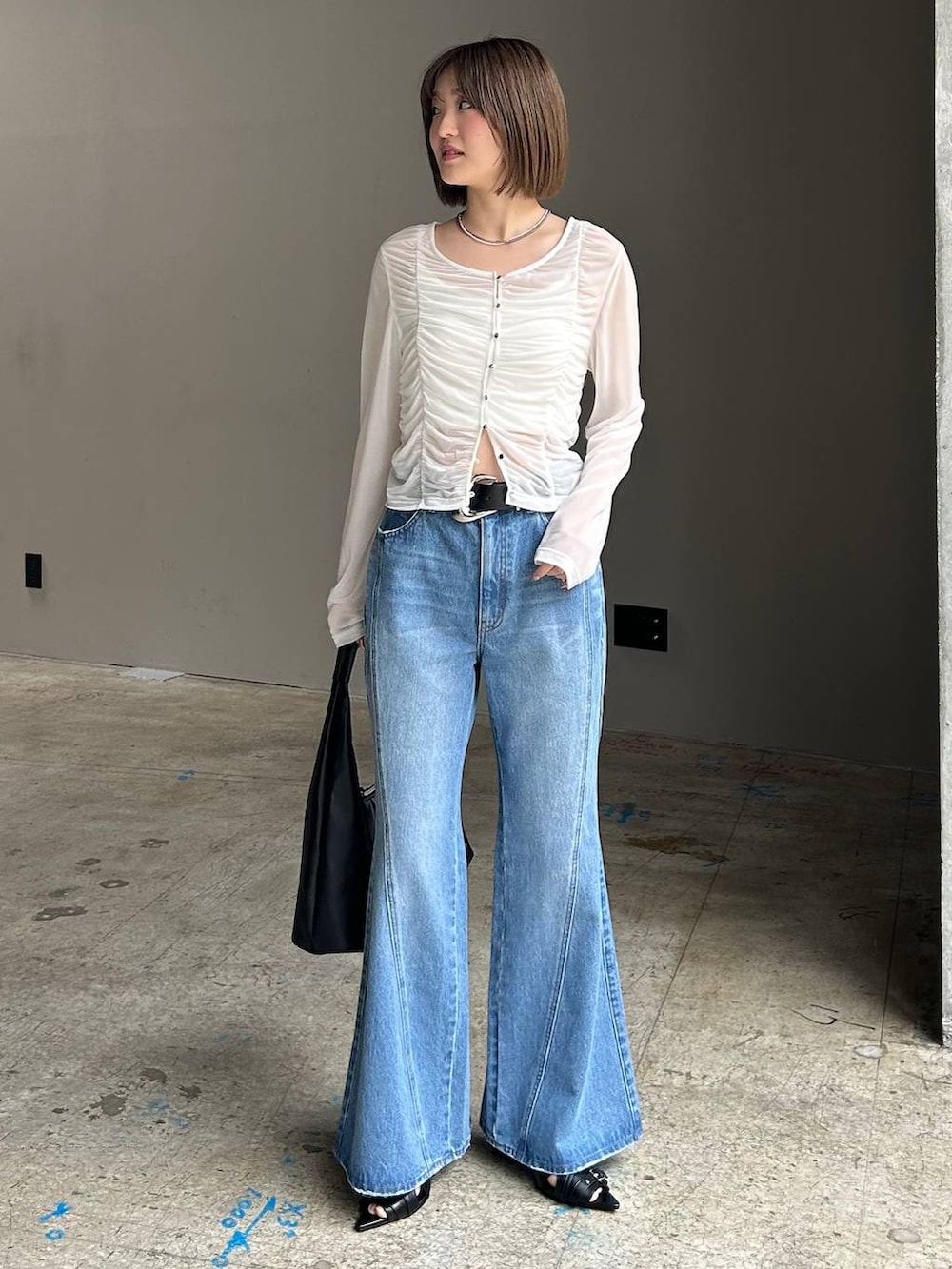 ブルー系のデニムパンツ、ブラック系のトートバッグ、ホワイト系のTシャツ/カットソーを着用したレディースの春コーディネートの6枚目の写真