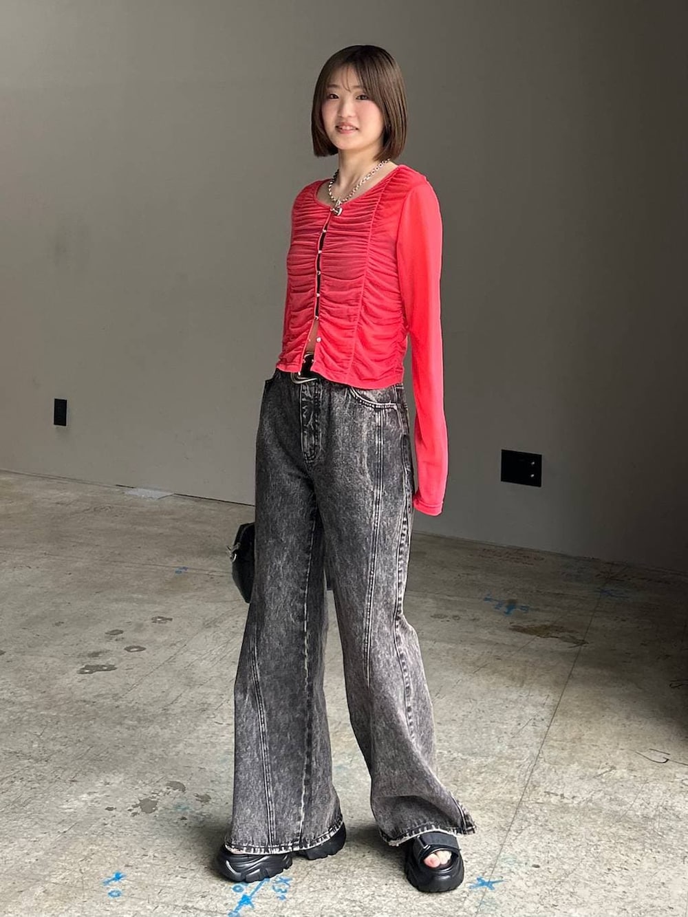 ブラック系のキャミソール、ブラック系のデニムパンツ、ブラック系のボストンバッグを着用したレディースの春コーディネートの2枚目の写真