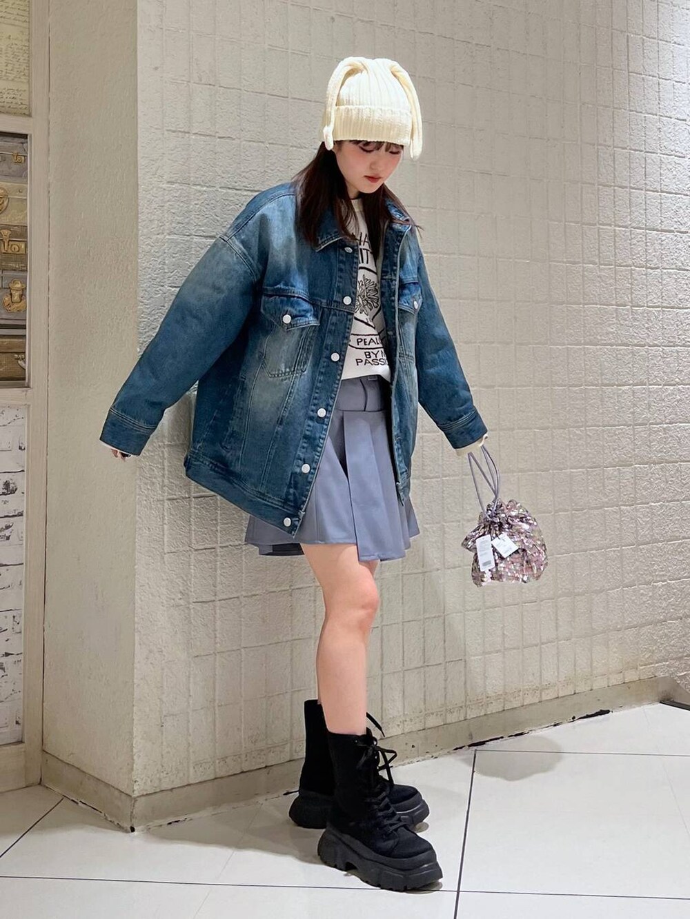 ホワイト系のニット/セーター、ブルー系のデニムジャケット、ブラック系のブーツを着用したレディースの冬コーディネートの3枚目の写真