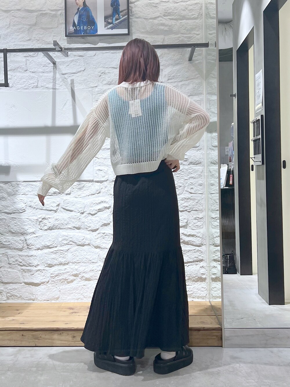 ホワイト系のカーディガン/ボレロ、ブラック系のスカート、ブラック系のサンダルを着用したレディースの春コーディネートの3枚目の写真