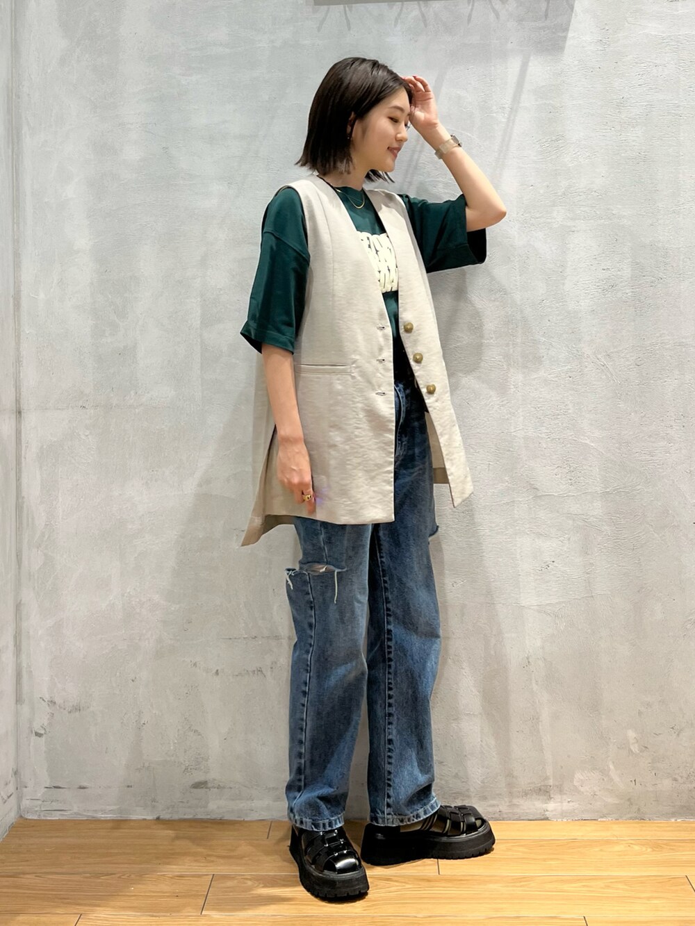 ブルー系のデニムパンツ、ブラック系のサンダル、ベージュ系のその他アウターを着用したレディースの夏コーディネートの3枚目の写真
