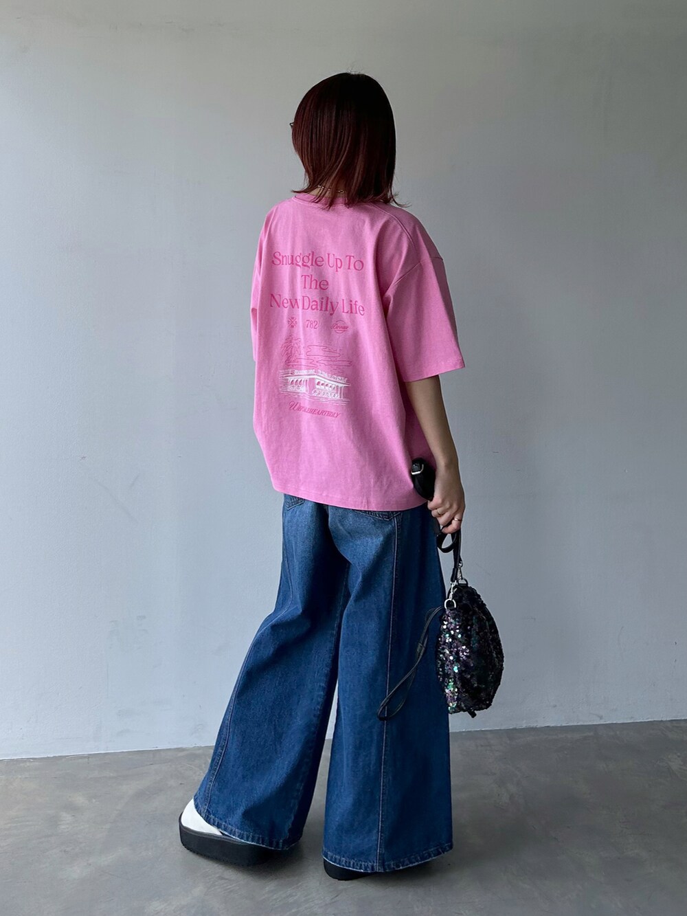 ピンク系のTシャツ/カットソー、ブルー系のデニムパンツ、ブラック系のショルダーバッグを着用したレディースの春コーディネートの3枚目の写真