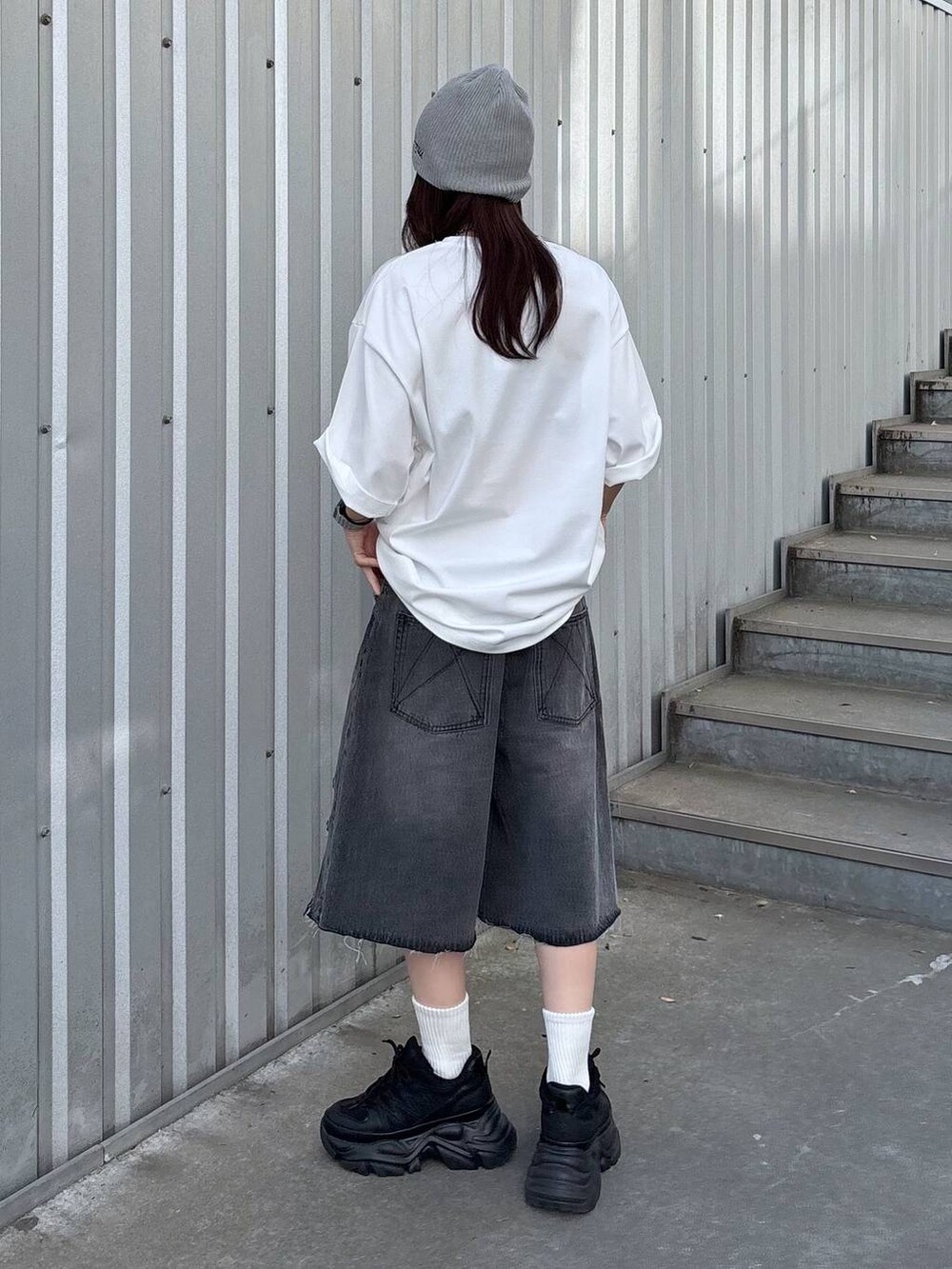 ブラック系のスニーカー、ブラック系のデニムパンツ、ホワイト系のTシャツ/カットソーを着用したレディースの春コーディネートの4枚目の写真