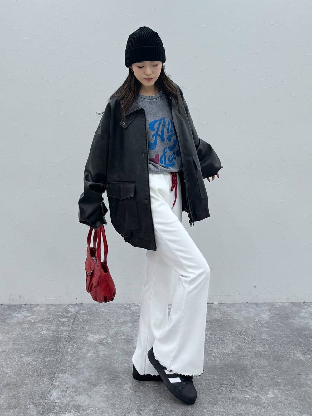 ブラック系のブルゾン、レッド系のハンドバッグ、ベージュ系のその他パンツを着用したレディースの冬コーディネートの5枚目の写真