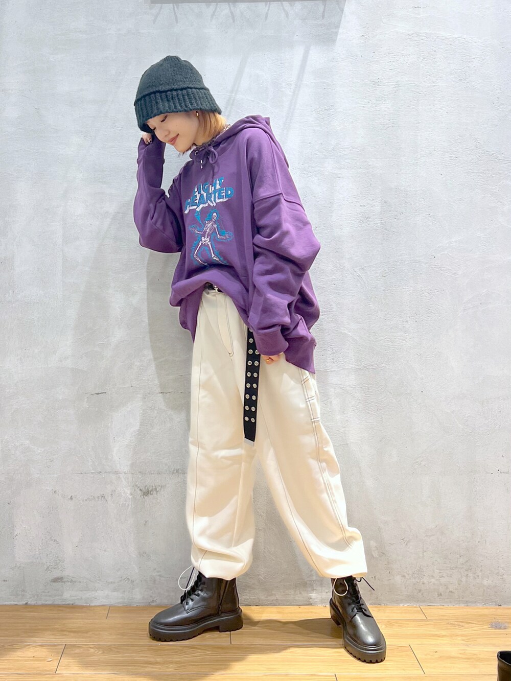 パープル系のパーカー、ホワイト系のその他パンツ、ブラック系のブーツを着用したレディースの秋コーディネートの2枚目の写真