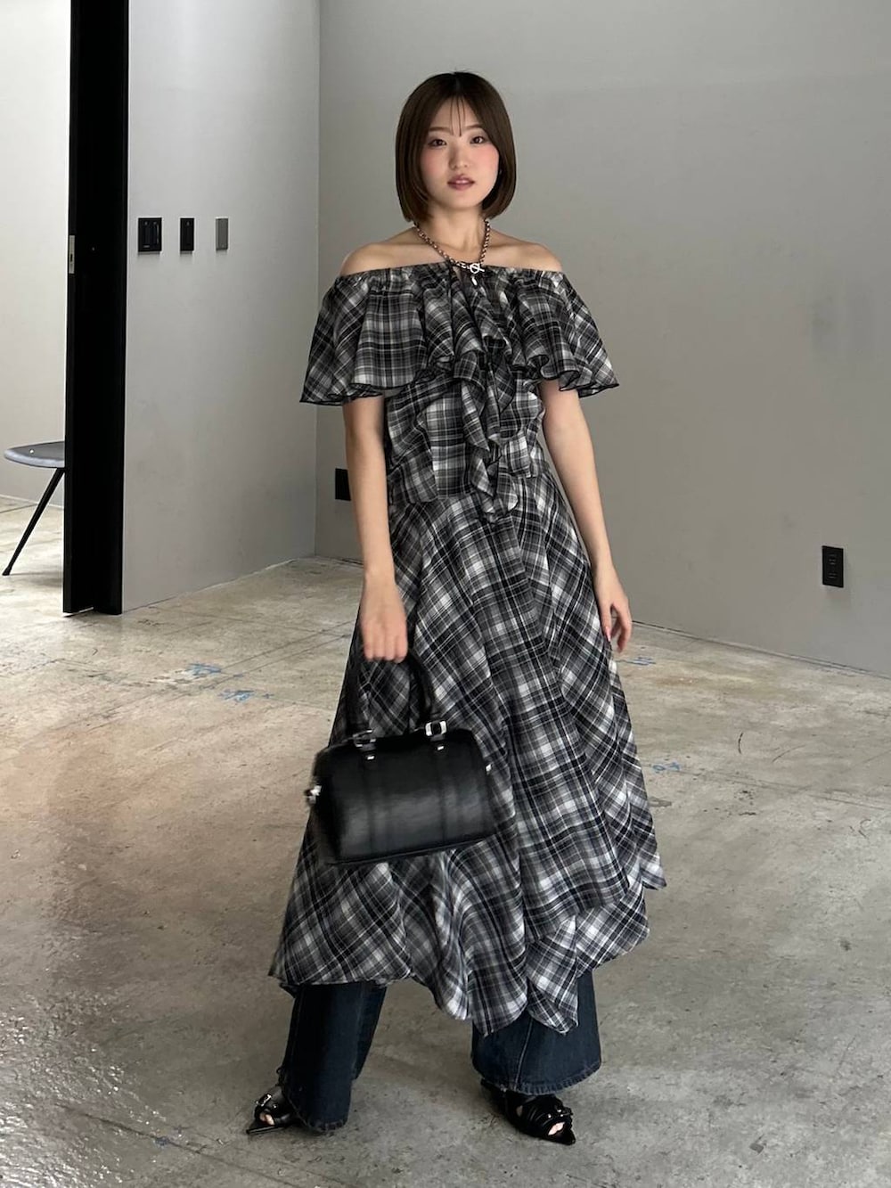 ブルー系のデニムパンツ、ブラック系のボストンバッグ、ブラック系のサンダルを着用したレディースの春コーディネートの2枚目の写真