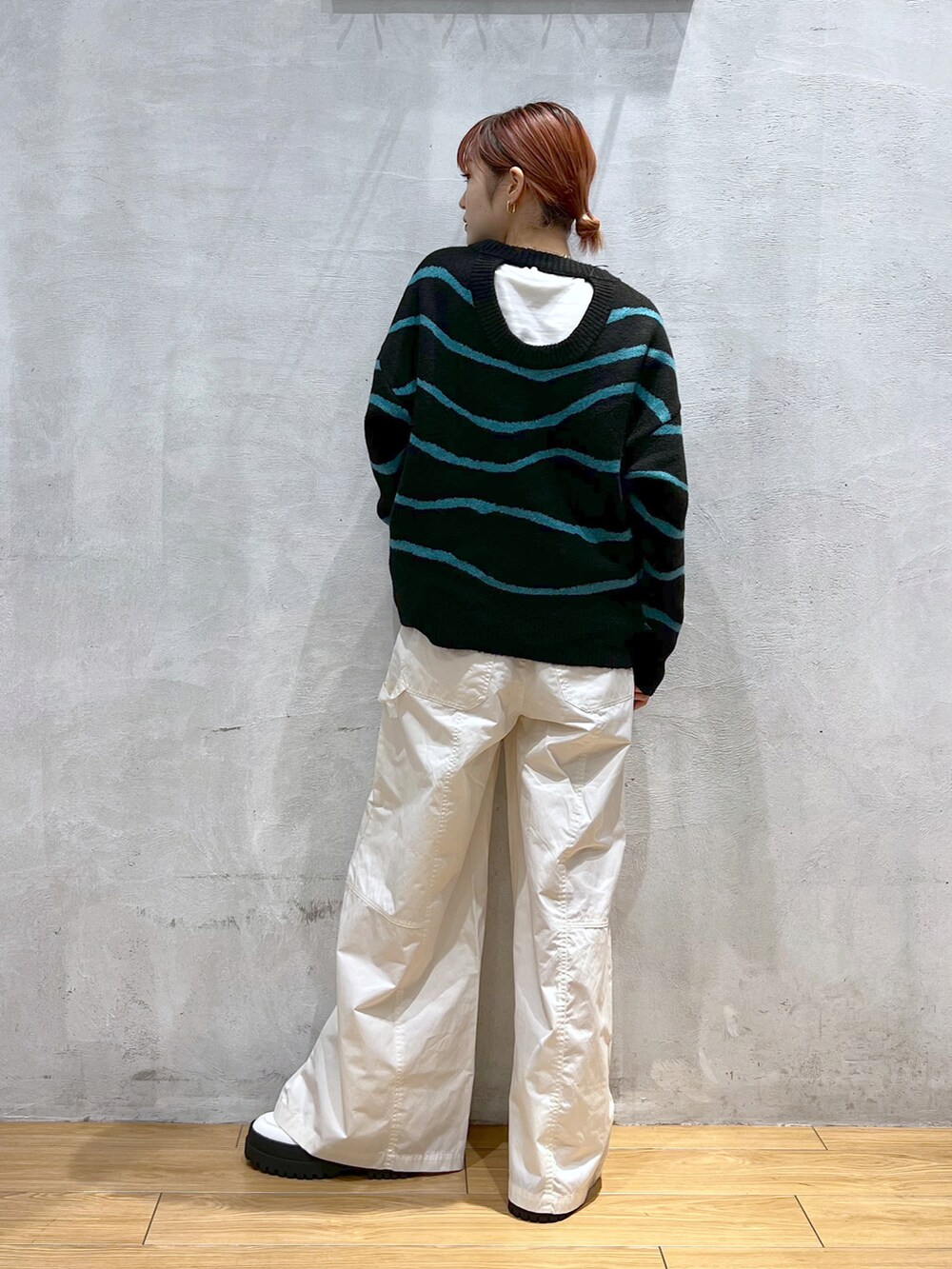 ブラック系のニット/セーター、ホワイト系のその他パンツ、ホワイト系のブーツを着用したレディースの冬コーディネートの2枚目の写真