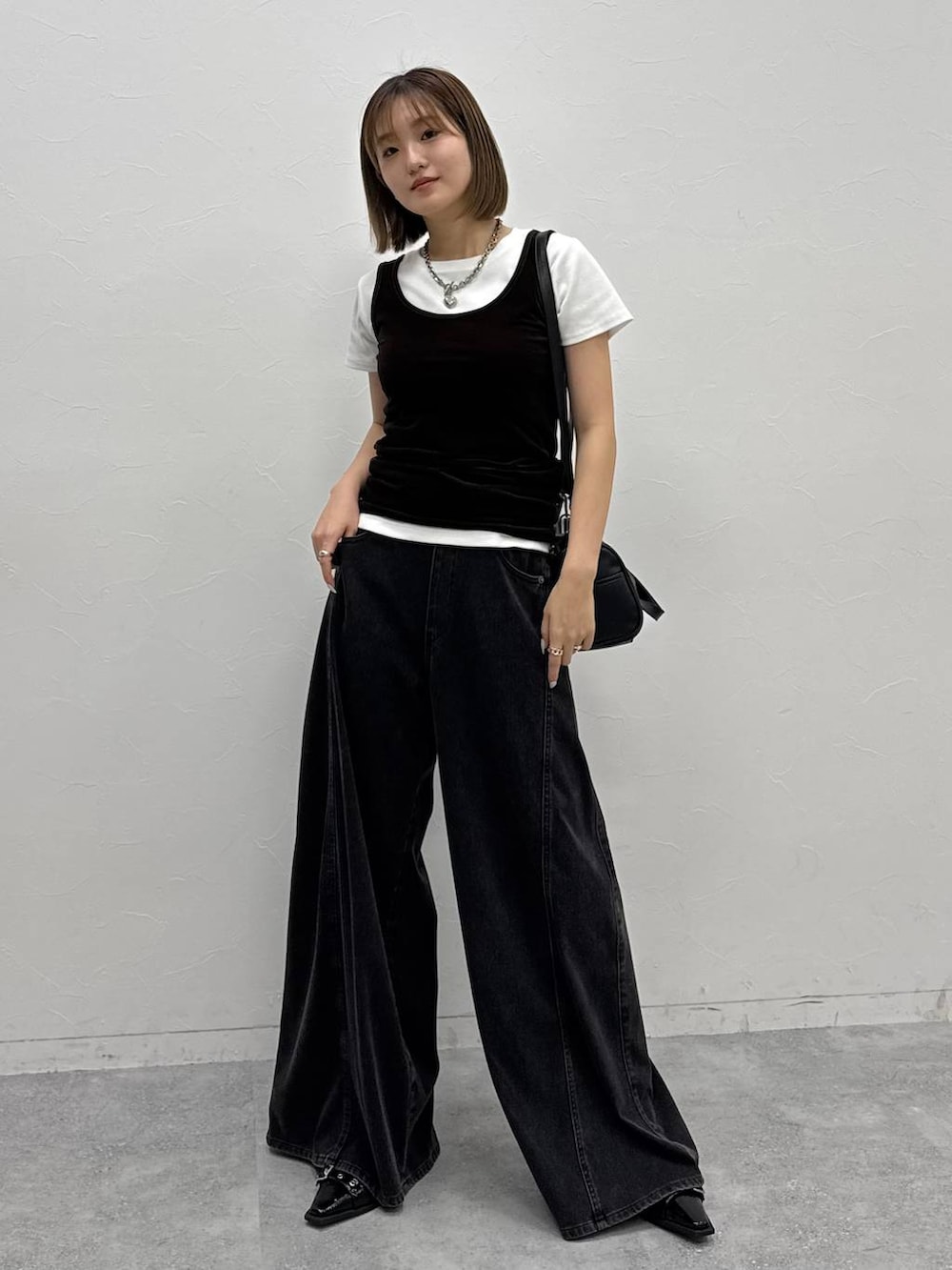 ブラック系のデニムパンツ、ブラック系のショルダーバッグ、ブラック系のタンクトップを着用したレディースの夏コーディネートの7枚目の写真