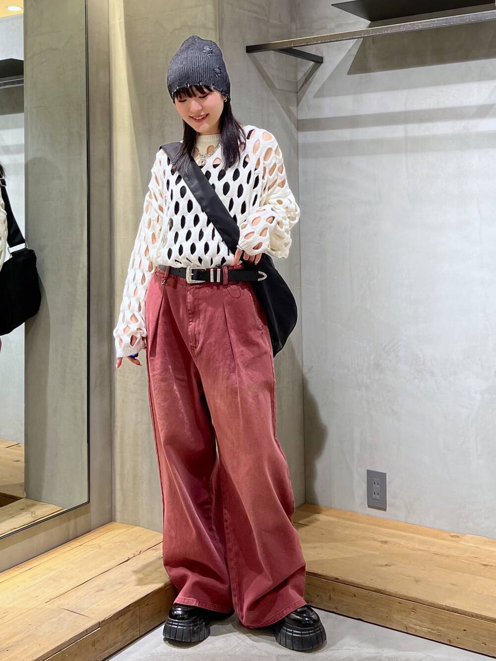 レッド系のデニムパンツ、ブラック系のローファー、ホワイト系のニット/セーターを着用したレディースの冬コーディネートの6枚目の写真