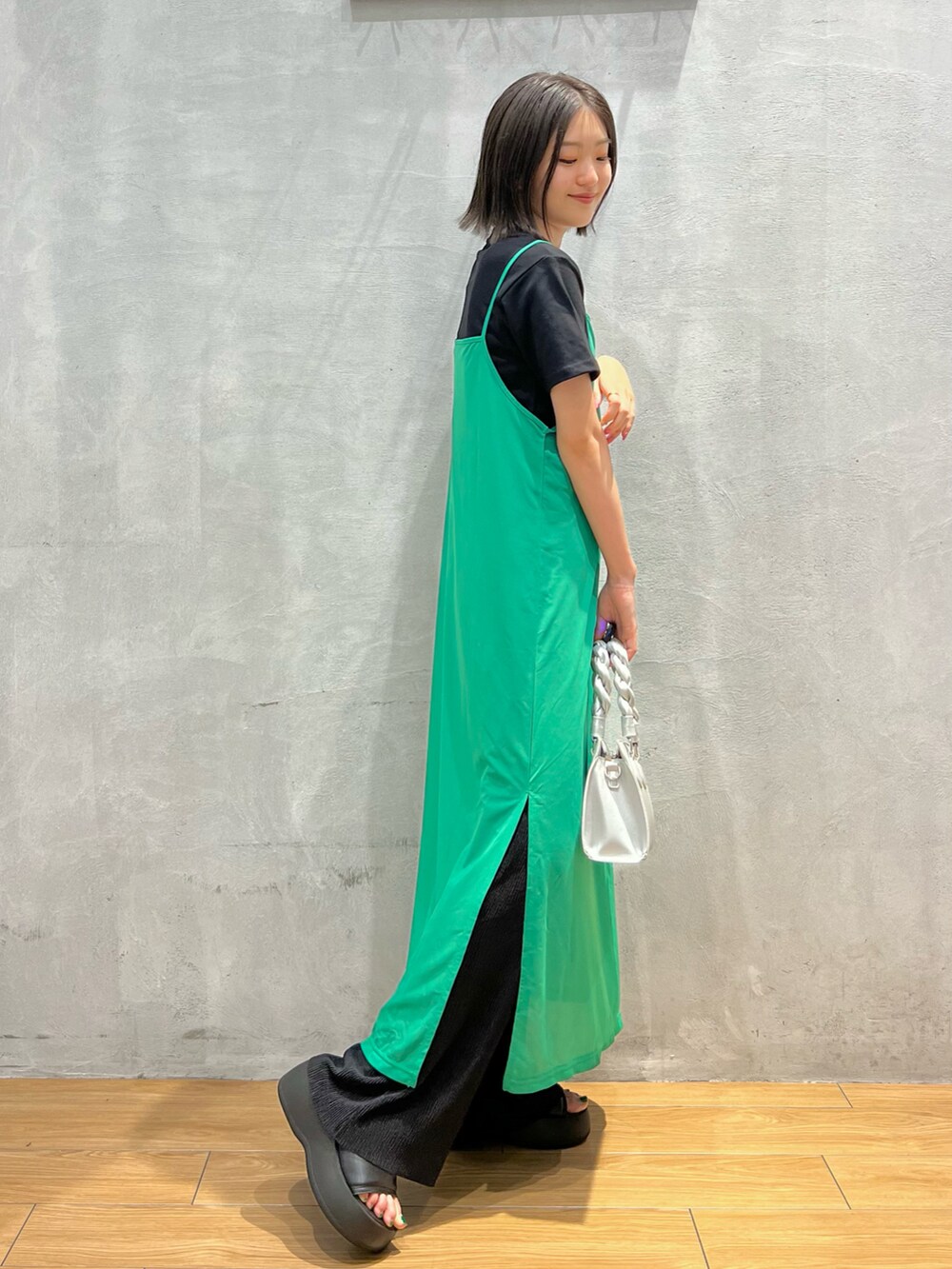 シルバー系のショルダーバッグ、グリーン系のワンピース、ブラック系のその他パンツを着用したレディースの夏コーディネートの3枚目の写真