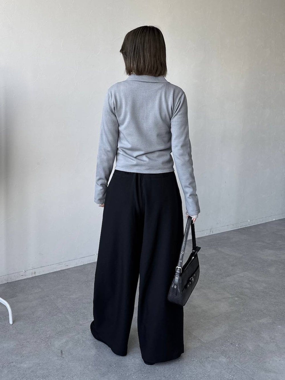 ブラック系のハンドバッグ、ブラック系のスラックス、ブラック系のモカシン/デッキシューズを着用したレディースの冬コーディネートの5枚目の写真