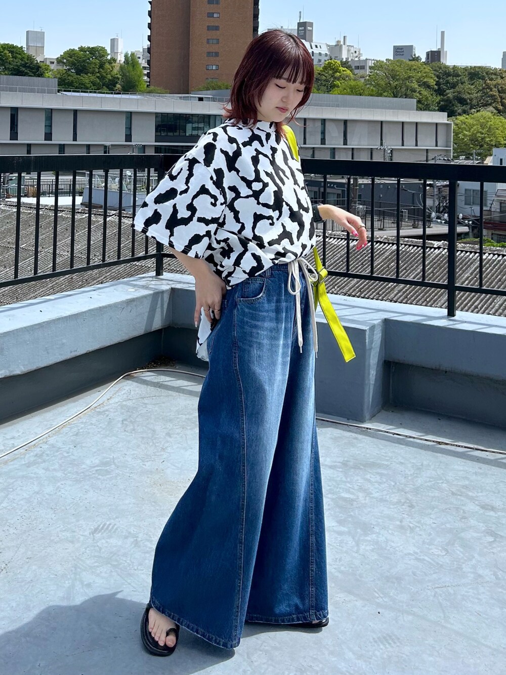 ブルー系のデニムパンツ、ホワイト系のTシャツ/カットソー、イエロー系のショルダーバッグを着用したレディースの春コーディネートの2枚目の写真