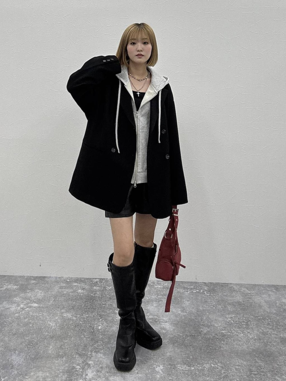 ブラック系のブーツ、グレー系のパーカー、グレー系のテーラードジャケットを着用したレディースの秋コーディネートの2枚目の写真