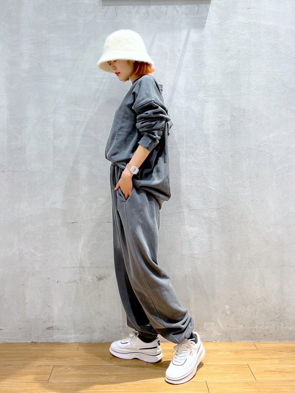 グレー系のスウェット、グレー系のスウェットパンツ、ホワイト系のスニーカーを着用したレディースの秋コーディネートの2枚目の写真