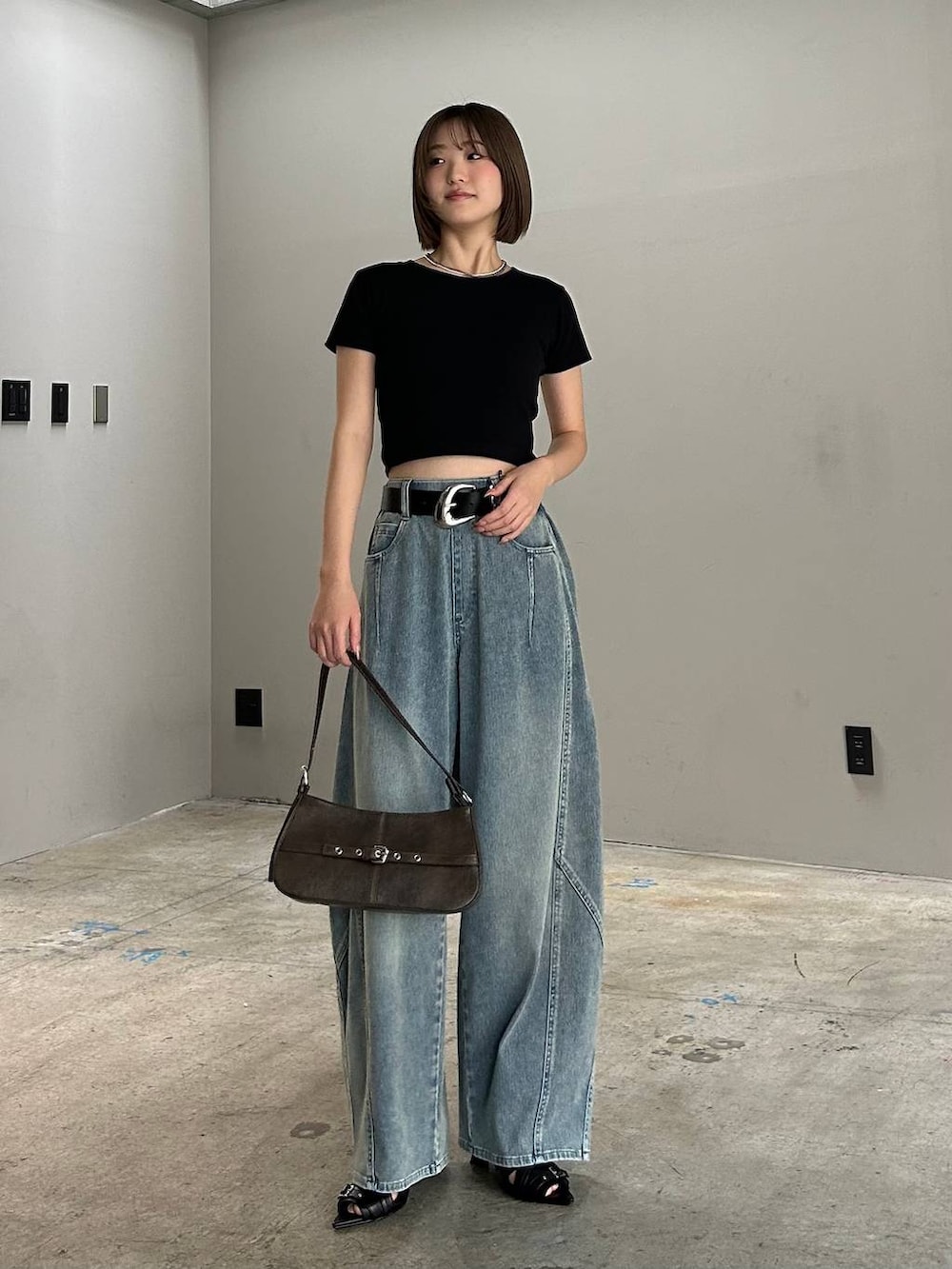 ブラック系のハンドバッグ、ブルー系のデニムパンツ、ブラック系のTシャツ/カットソーを着用したレディースの春コーディネートの3枚目の写真