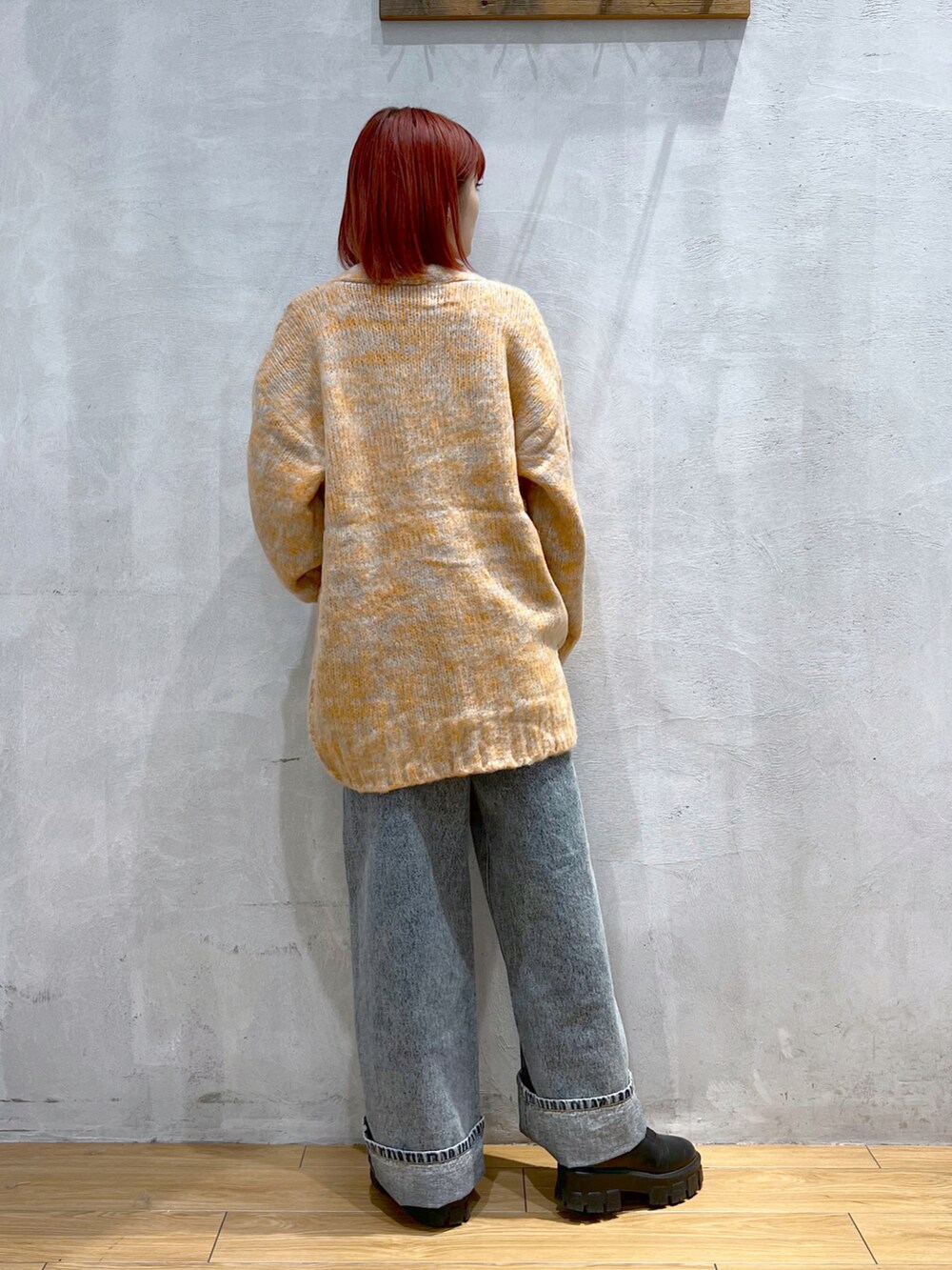 オレンジ系のカーディガン/ボレロ、ホワイト系のTシャツ/カットソー、ブルー系のデニムパンツを着用したレディースの秋コーディネートの3枚目の写真