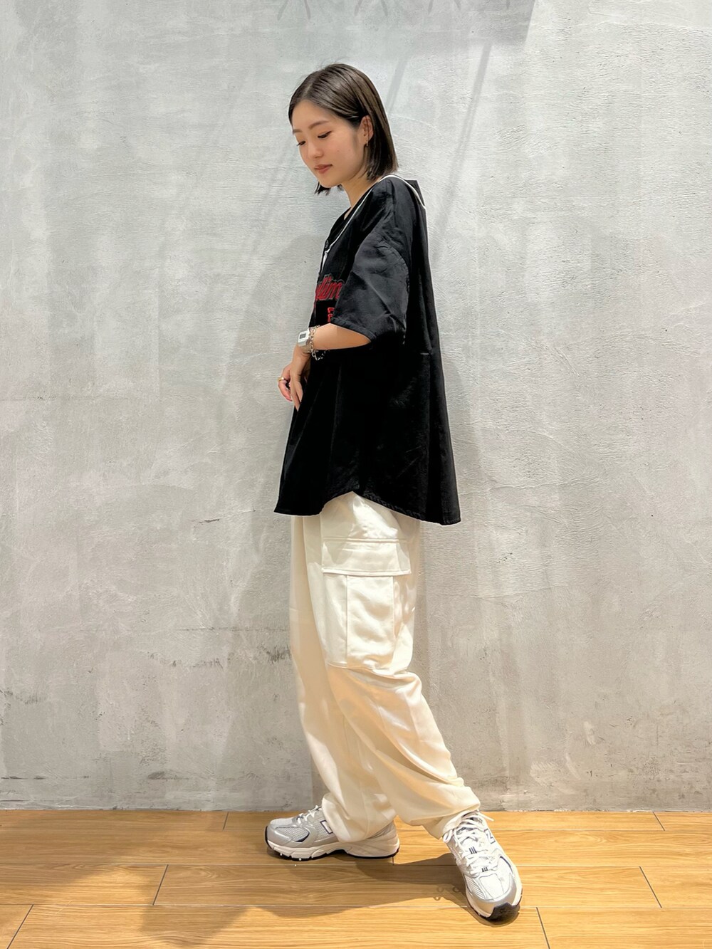 ホワイト系のパンツ、グレー系のスニーカー、ブラック系のシャツ/ブラウスを着用したレディースの夏コーディネートの2枚目の写真