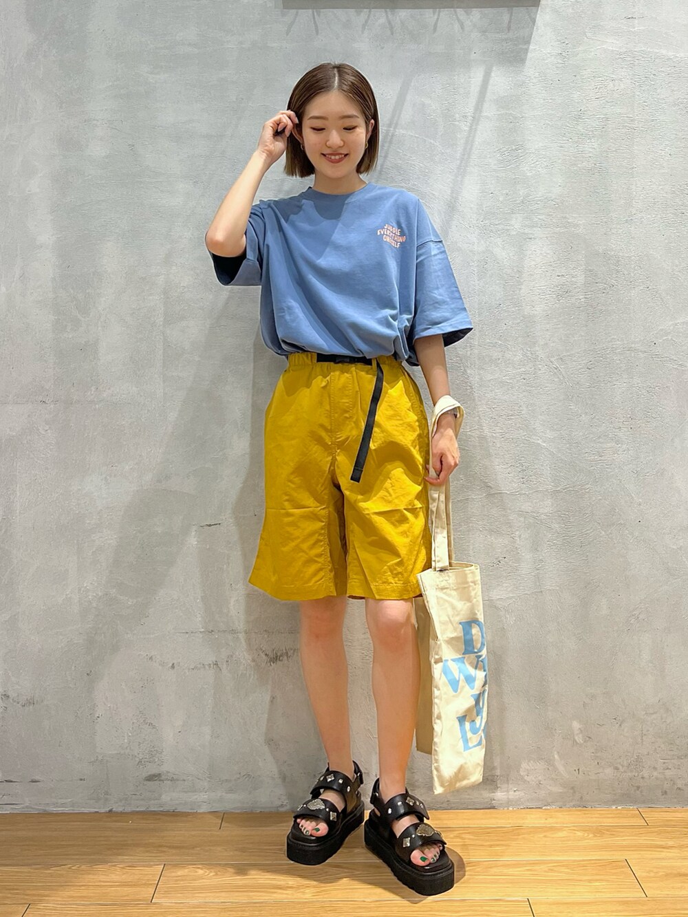 イエロー系のその他パンツ、ブルー系のTシャツ/カットソー、ブラック系のサンダルを着用したレディースの夏コーディネートの2枚目の写真
