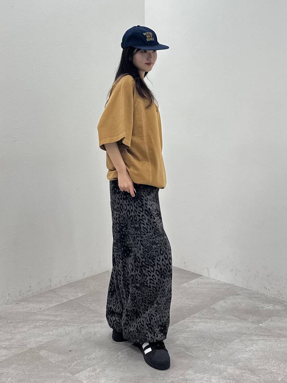 ブラック系のデニムパンツ、イエロー系のTシャツ/カットソー、ブルー系のキャップを着用したレディースの春コーディネートの4枚目の写真