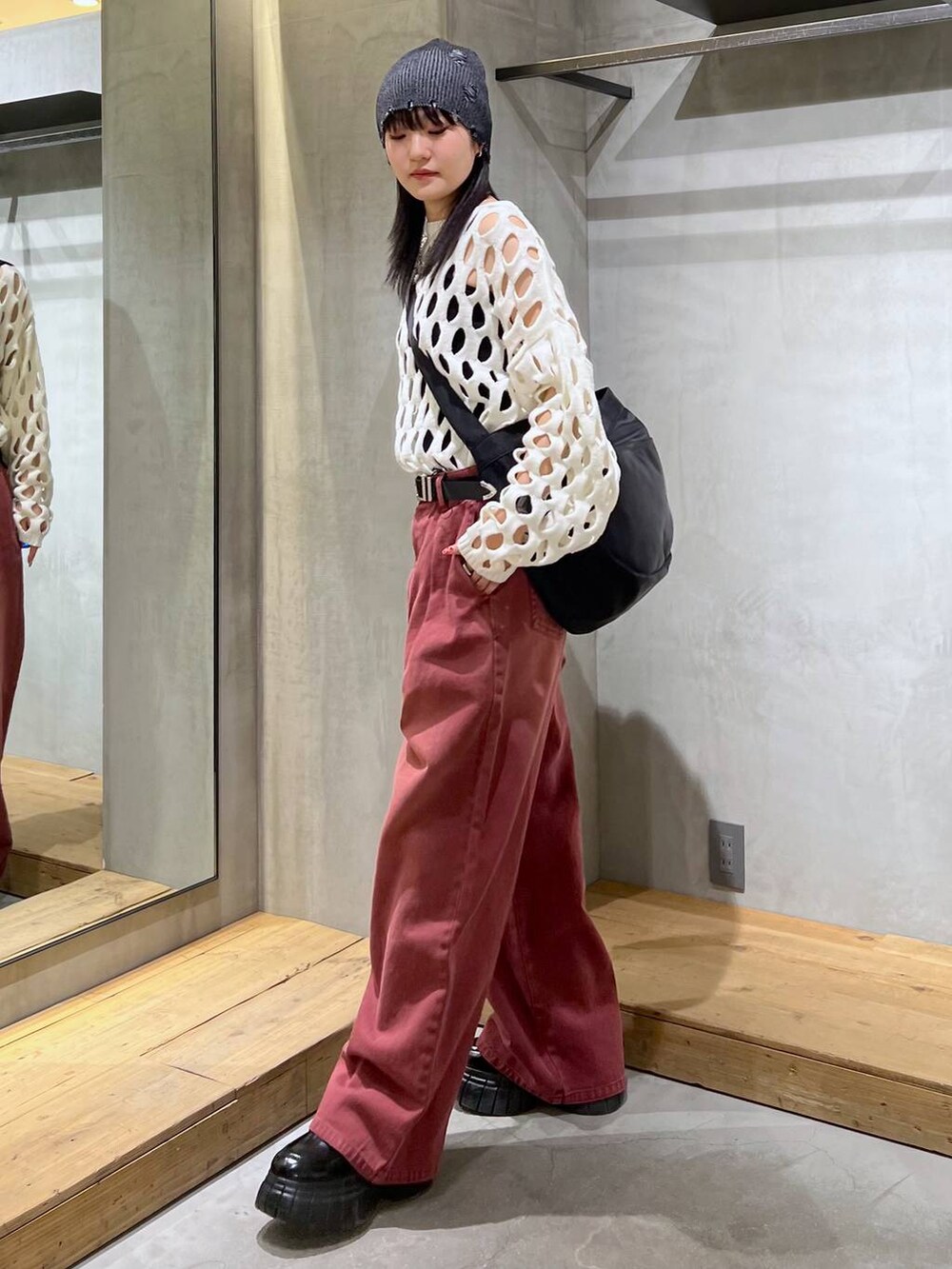 レッド系のデニムパンツ、ブラック系のローファー、ホワイト系のニット/セーターを着用したレディースの冬コーディネートの5枚目の写真
