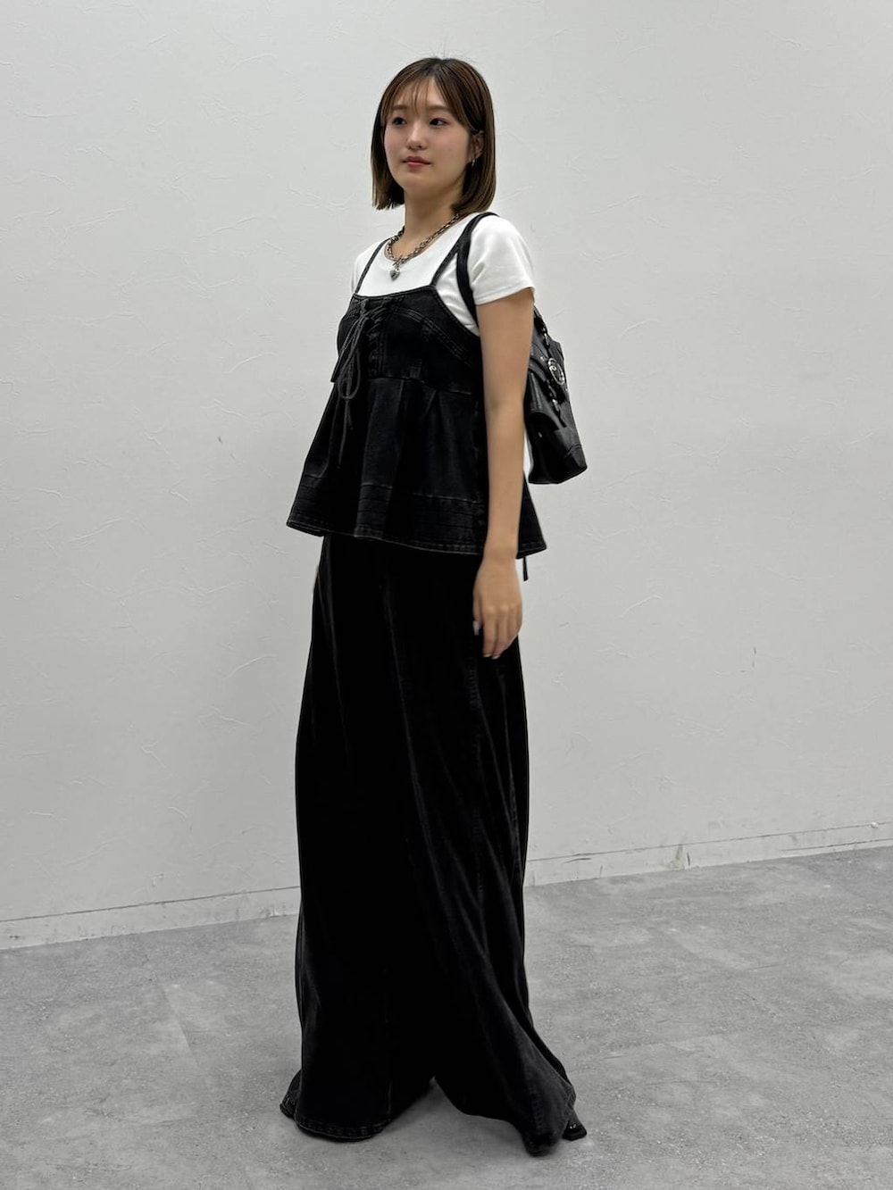 ブラック系のデニムパンツ、ブラック系のその他トップス、ホワイト系のTシャツ/カットソーを着用したレディースの夏コーディネートの2枚目の写真