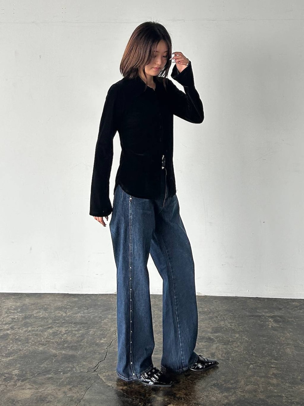 ブラック系のシャツ/ブラウス、ブルー系のデニムパンツ、ブラック系のベルトを着用したレディースの秋コーディネートの6枚目の写真