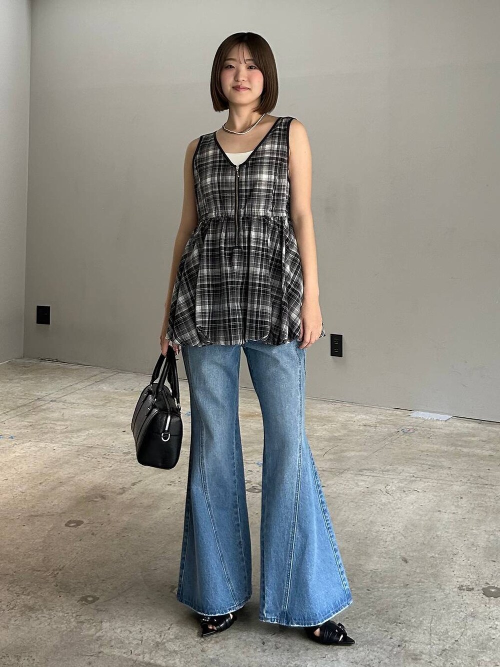 ブルー系のデニムパンツ、ブラック系のボストンバッグ、ブラック系のサンダルを着用したレディースの春コーディネートの8枚目の写真