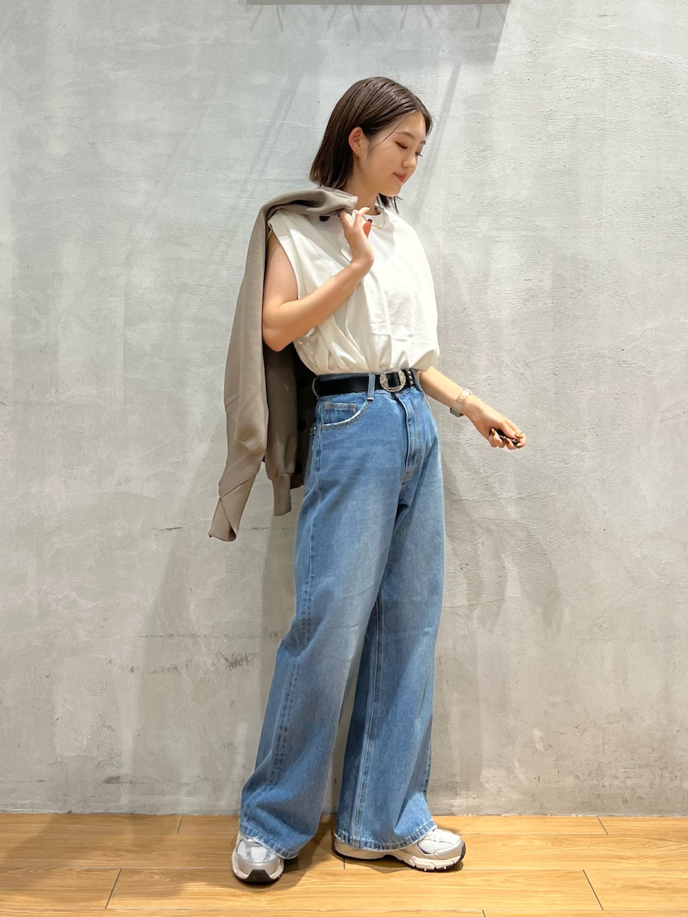 ブルー系のデニムパンツ、グレー系のスニーカー、ホワイト系のTシャツ/カットソーを着用したレディースの秋コーディネートの5枚目の写真