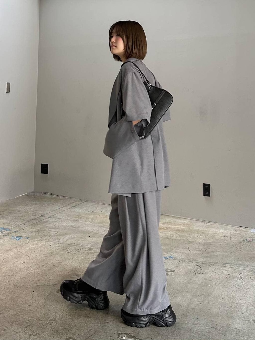 ブラック系のブーツ、ブラック系のキャミソール、ブラック系のハンドバッグを着用したレディースの春コーディネートの2枚目の写真