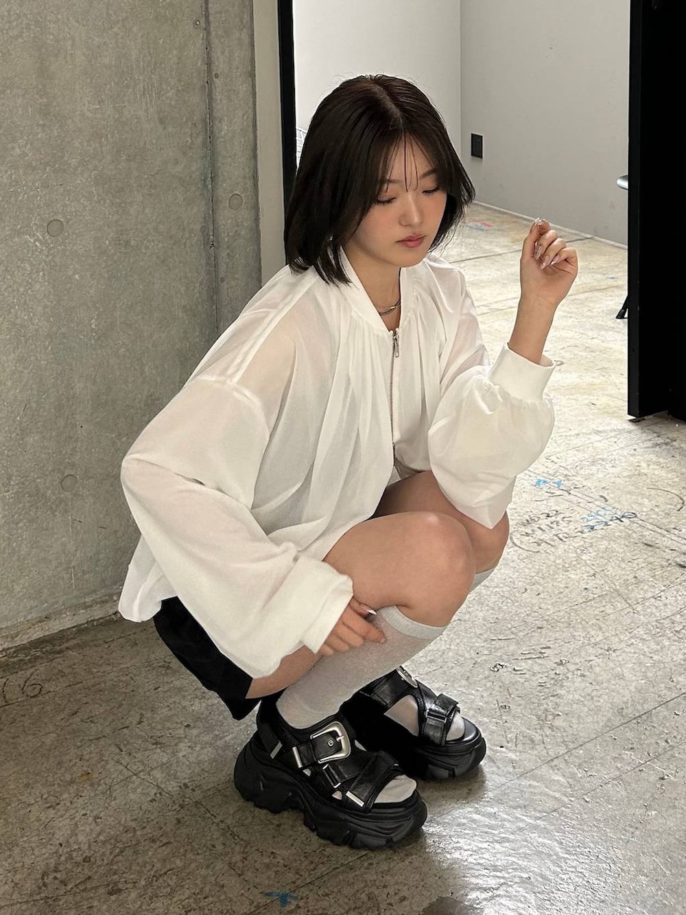 ブラック系のキャミソール、ホワイト系のブルゾン、ブラック系のサンダルを着用したレディースの春コーディネートの7枚目の写真