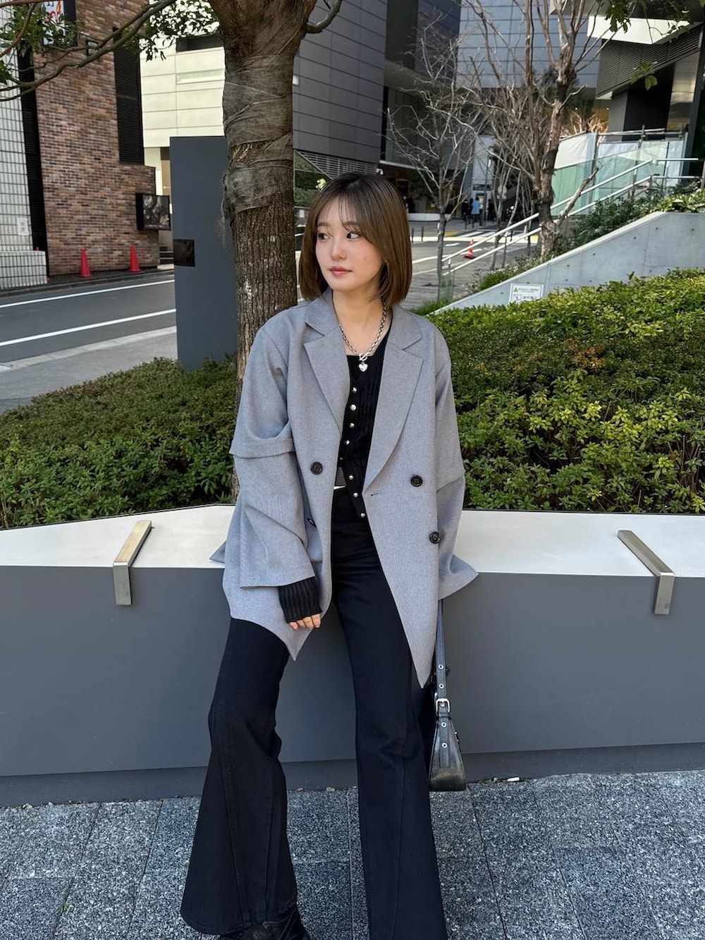 ブラック系のスニーカー、ブラック系のデニムパンツ、ブラック系のハンドバッグを着用したレディースの春コーディネートの3枚目の写真