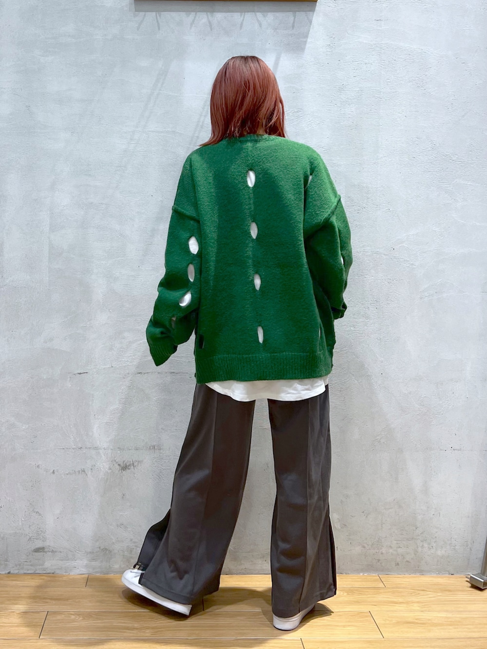 グリーン系のニット/セーター、グレー系のスウェットパンツ、ホワイト系のTシャツ/カットソーを着用したレディースの冬コーディネートの2枚目の写真