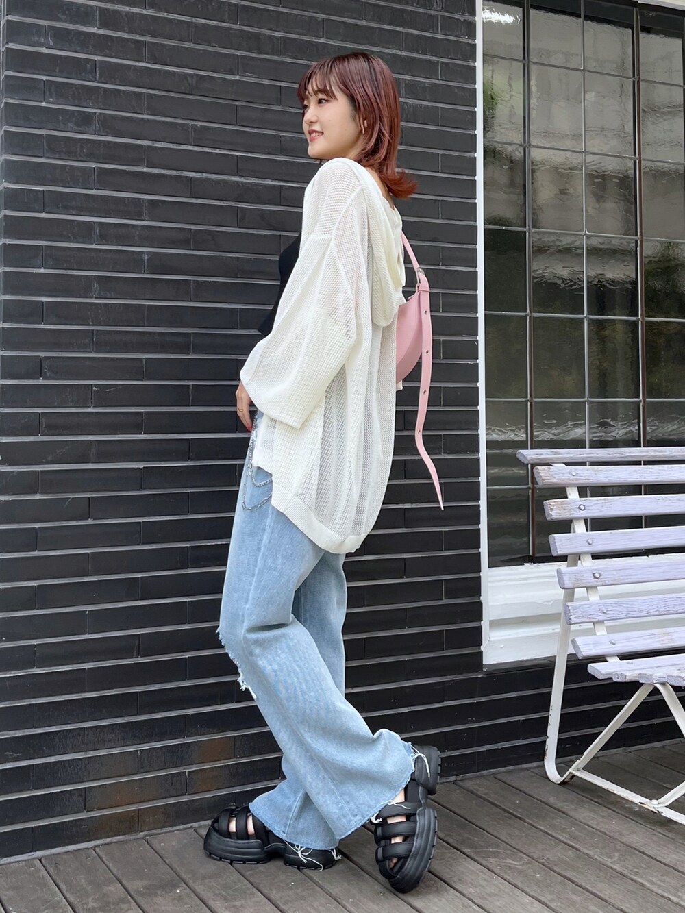 ブラック系のキャミソール、ピンク系のショルダーバッグ、ブルー系のデニムパンツを着用したレディースの夏コーディネートの2枚目の写真