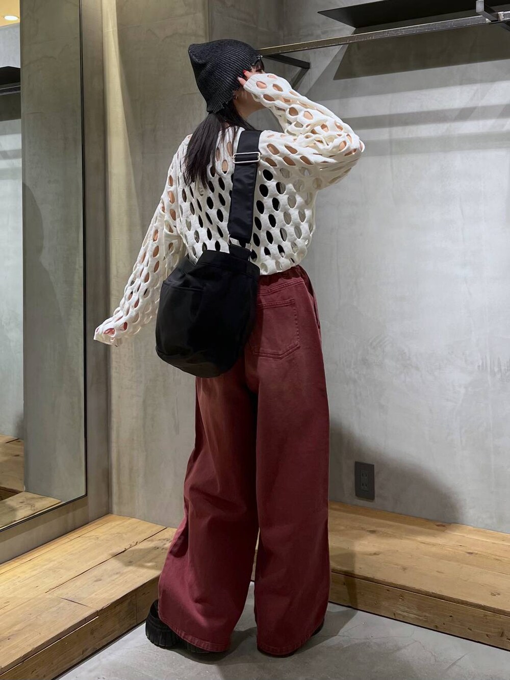 レッド系のデニムパンツ、ブラック系のローファー、ホワイト系のニット/セーターを着用したレディースの冬コーディネートの4枚目の写真