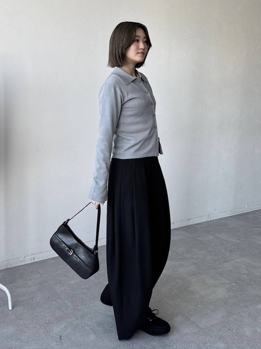 ブラック系のハンドバッグ、ブラック系のスラックス、ブラック系のモカシン/デッキシューズを着用したレディースの冬コーディネートの6枚目の写真