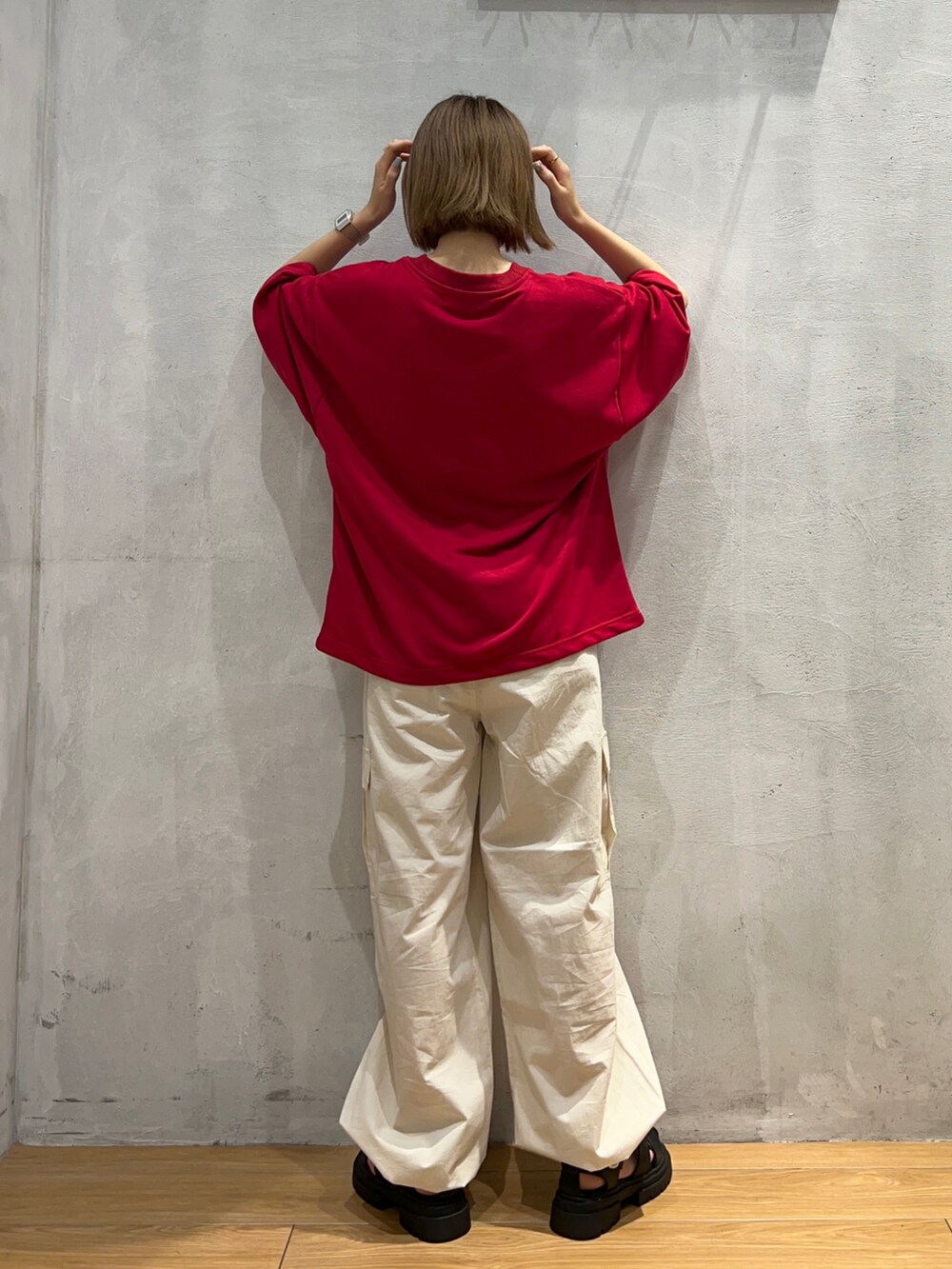 ブラック系のサンダル、ホワイト系のカーゴパンツ、レッド系のTシャツ/カットソーを着用したレディースの夏コーディネートの2枚目の写真