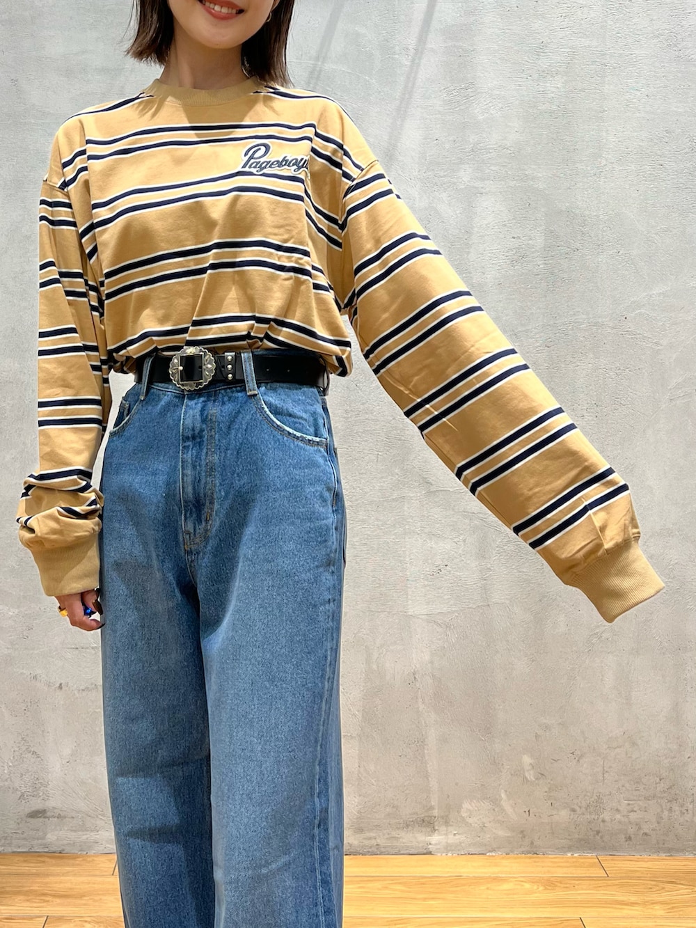 ブルー系のデニムパンツ、ブラック系のショルダーバッグ、グレー系のスニーカーを着用したレディースの秋コーディネートの5枚目の写真