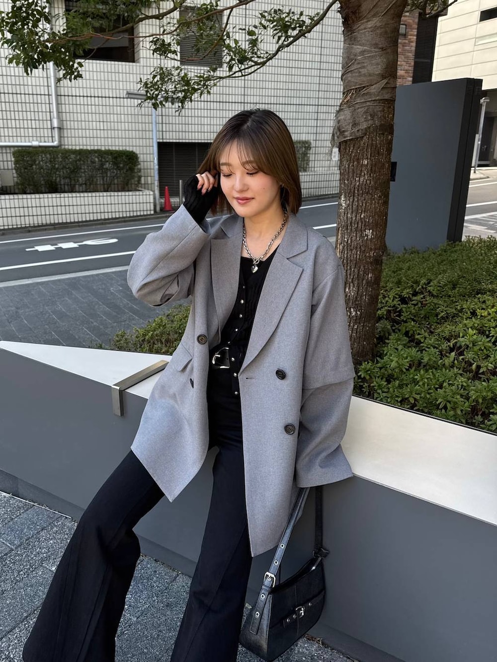 ブラック系のスニーカー、ブラック系のデニムパンツ、ブラック系のハンドバッグを着用したレディースの春コーディネートの2枚目の写真